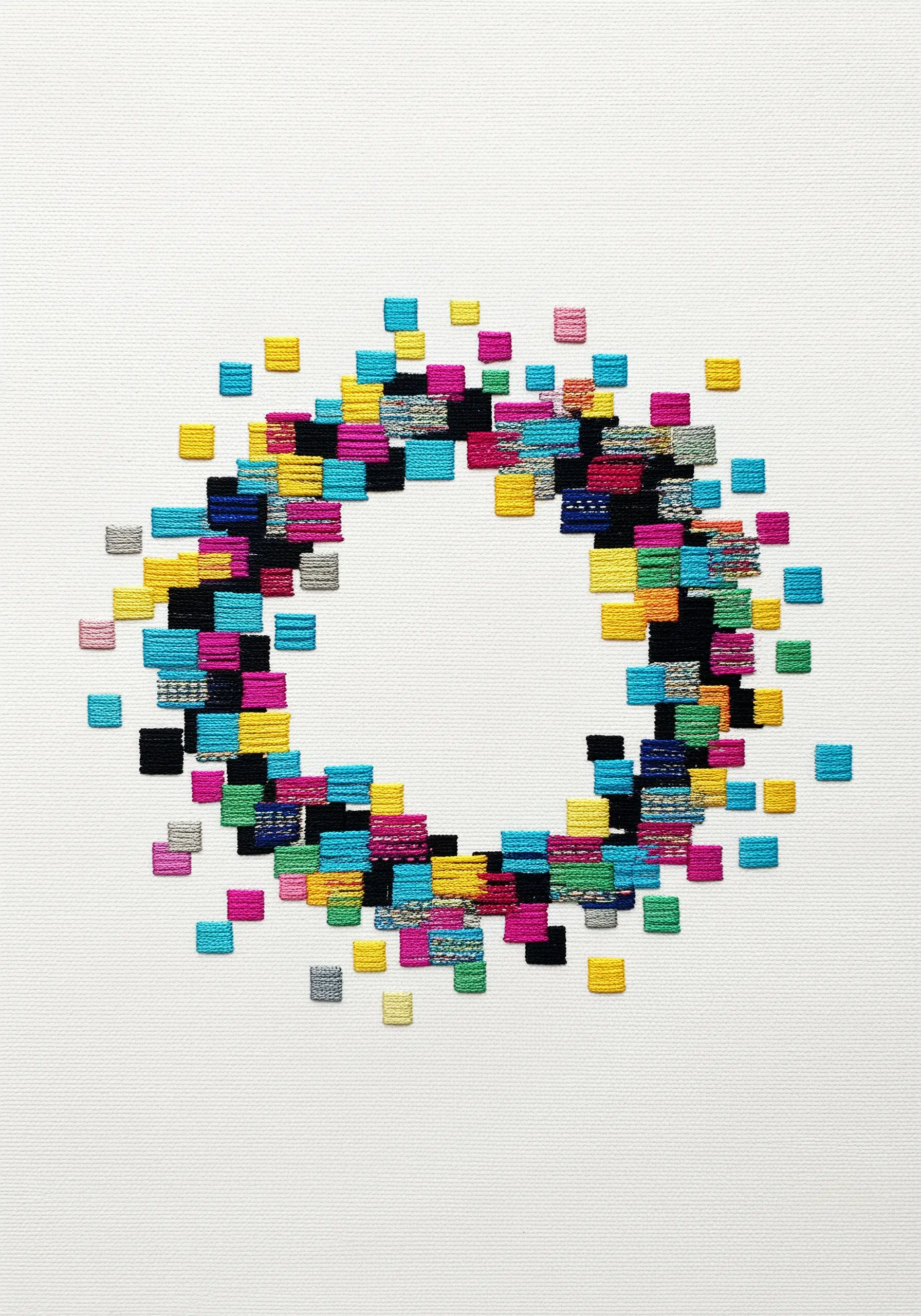 Abstract circle made of small, colorful, layered satin stitch blocks.