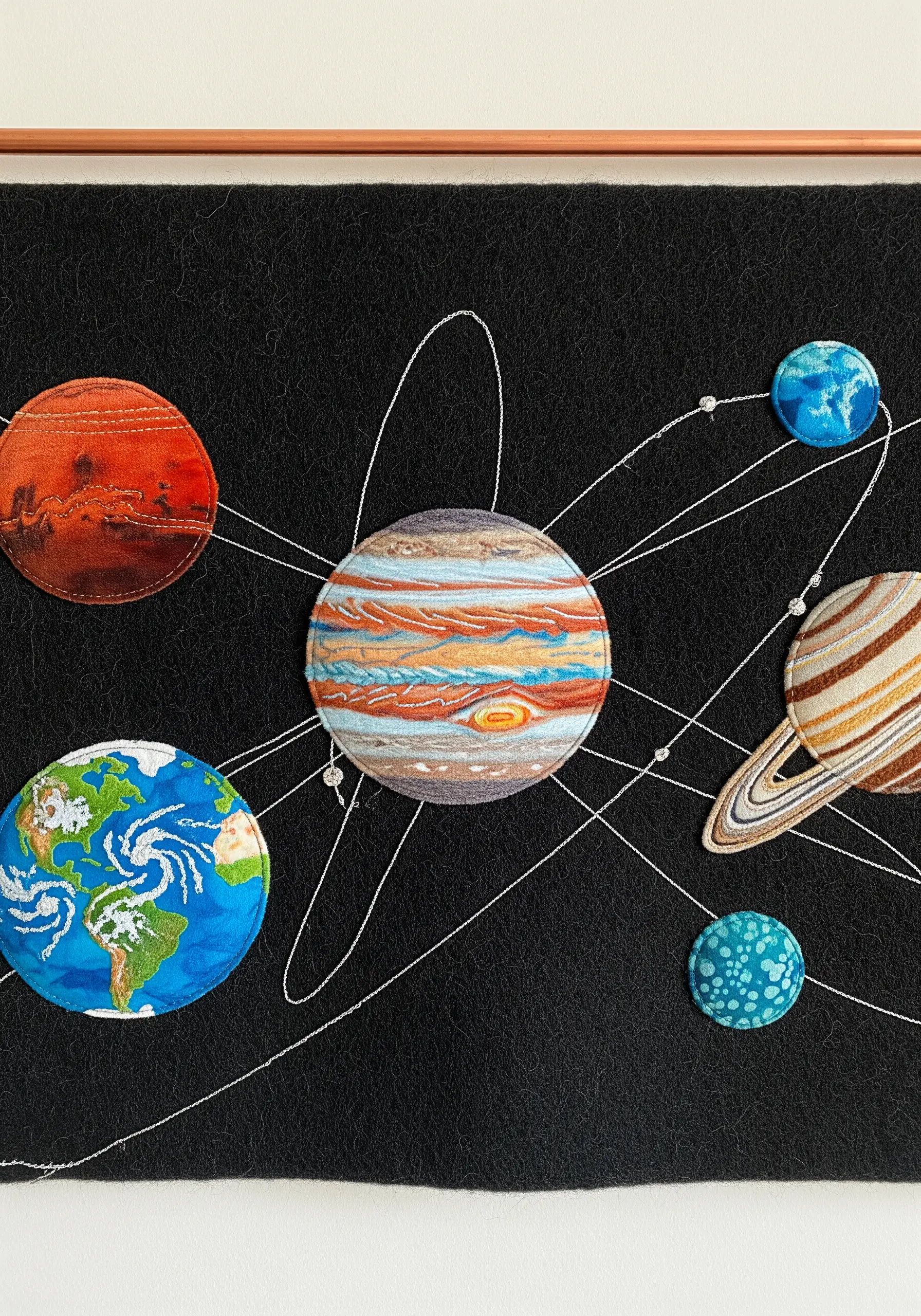 Appliqué patches of the solar system's planets stitched onto a black felt background.
