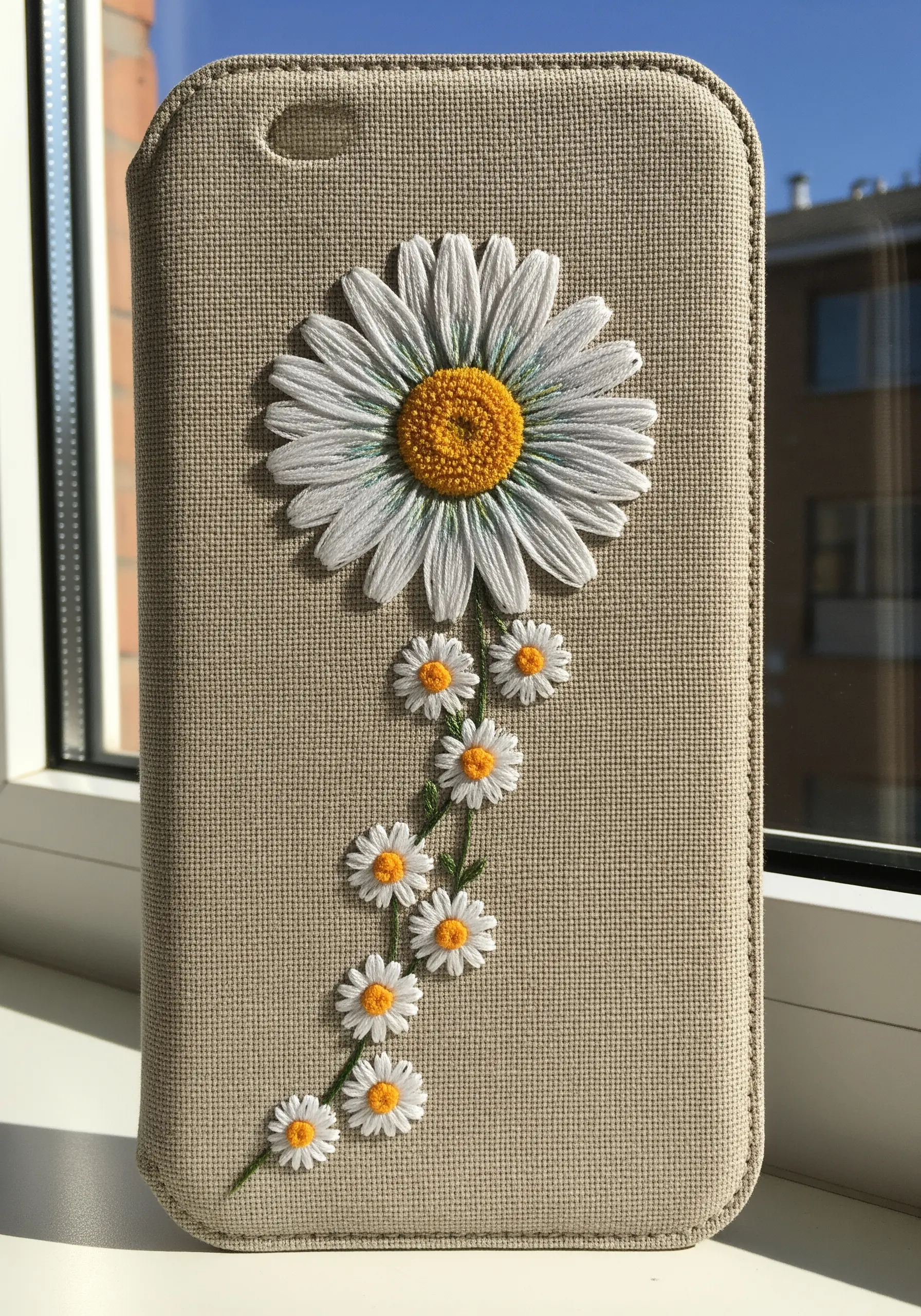 One large, detailed daisy at the top of a phone case with a trail of tiny daisies below.