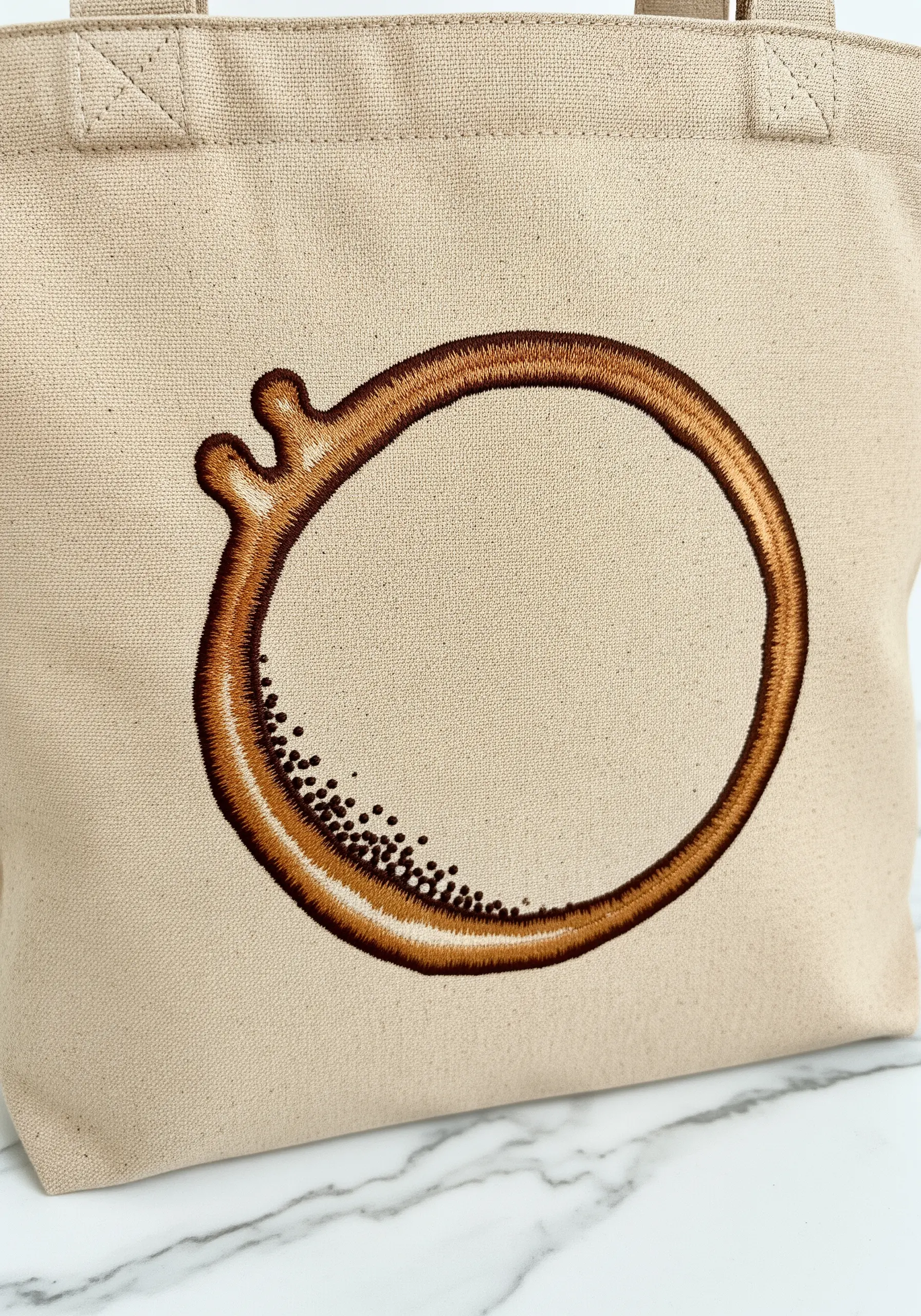 An embroidered coffee cup ring stain with realistic color blending and texture.