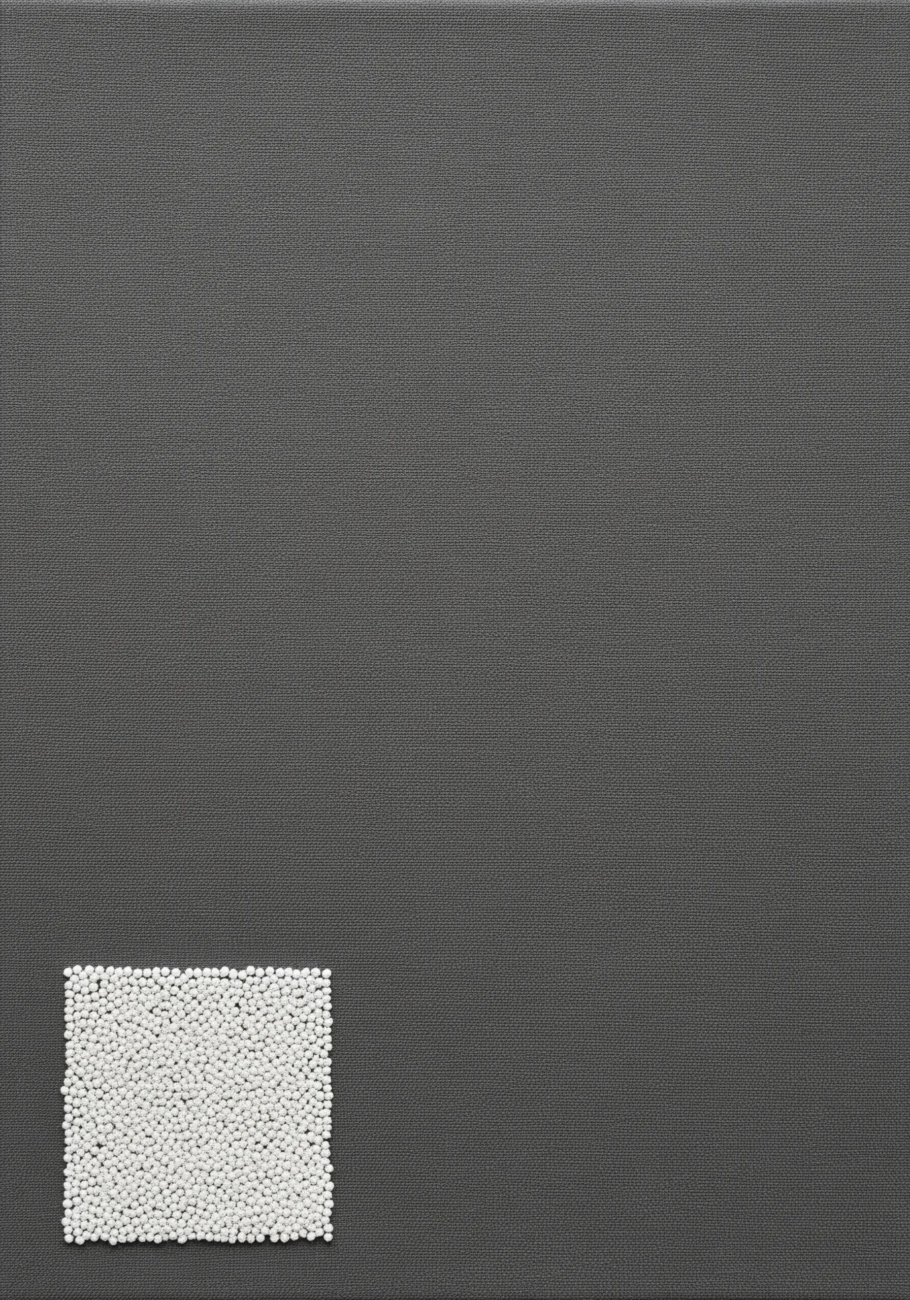 A small square filled with tiny white seed beads on a dark grey canvas.