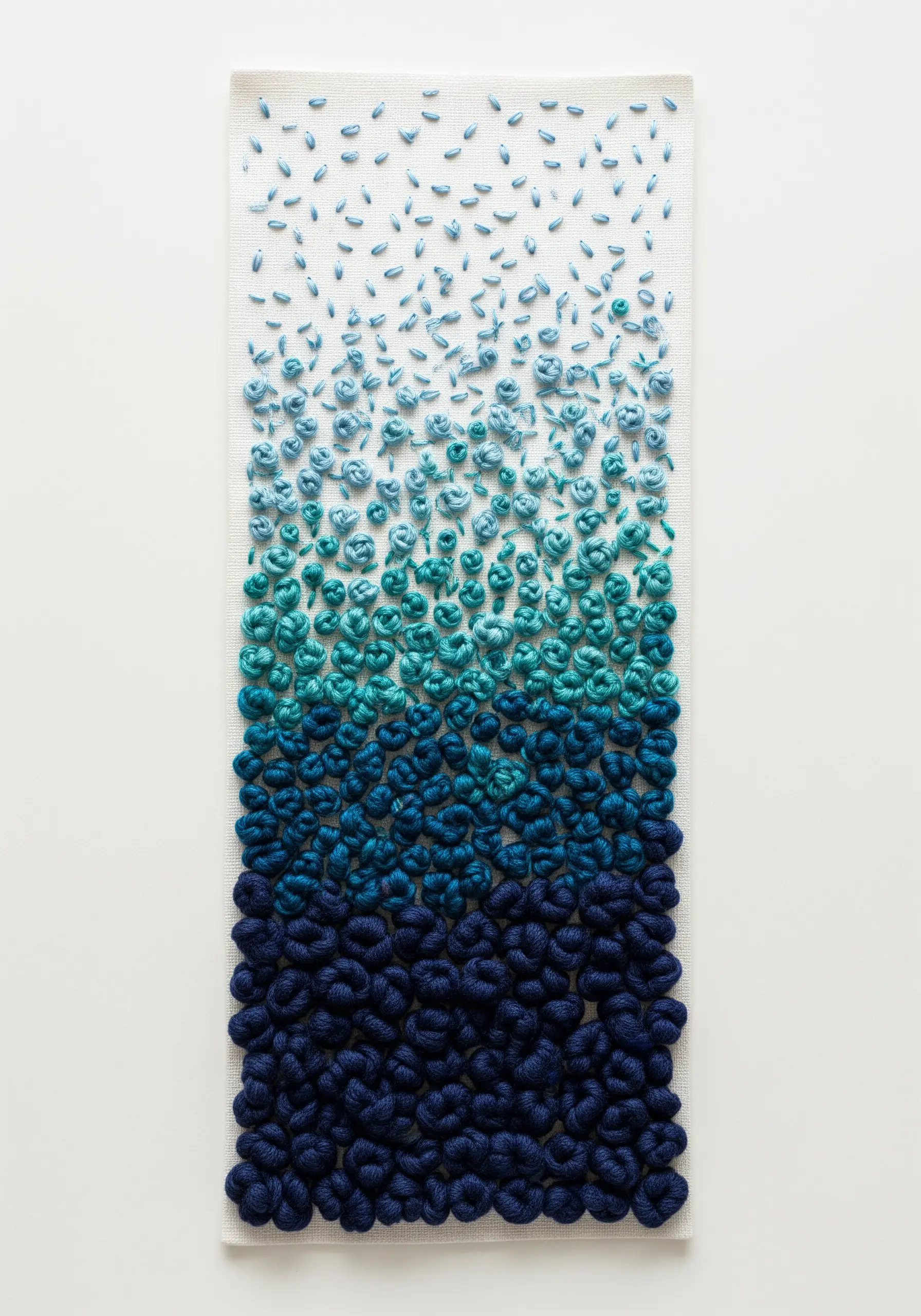 A vertical panel showing a dense gradient of blue French knots, from dark to light.