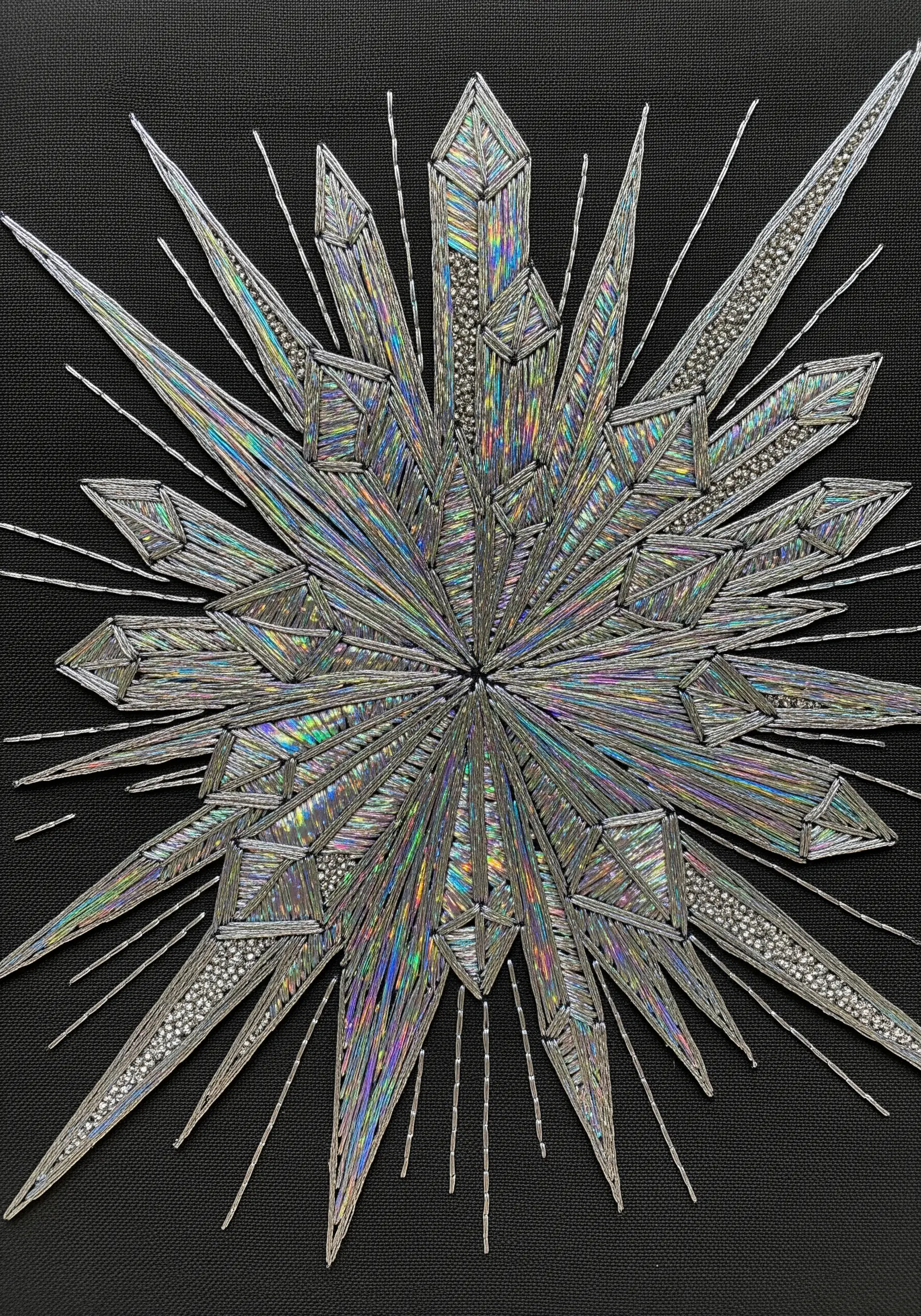 A starburst of crystals stitched with shimmering holographic and silver threads.