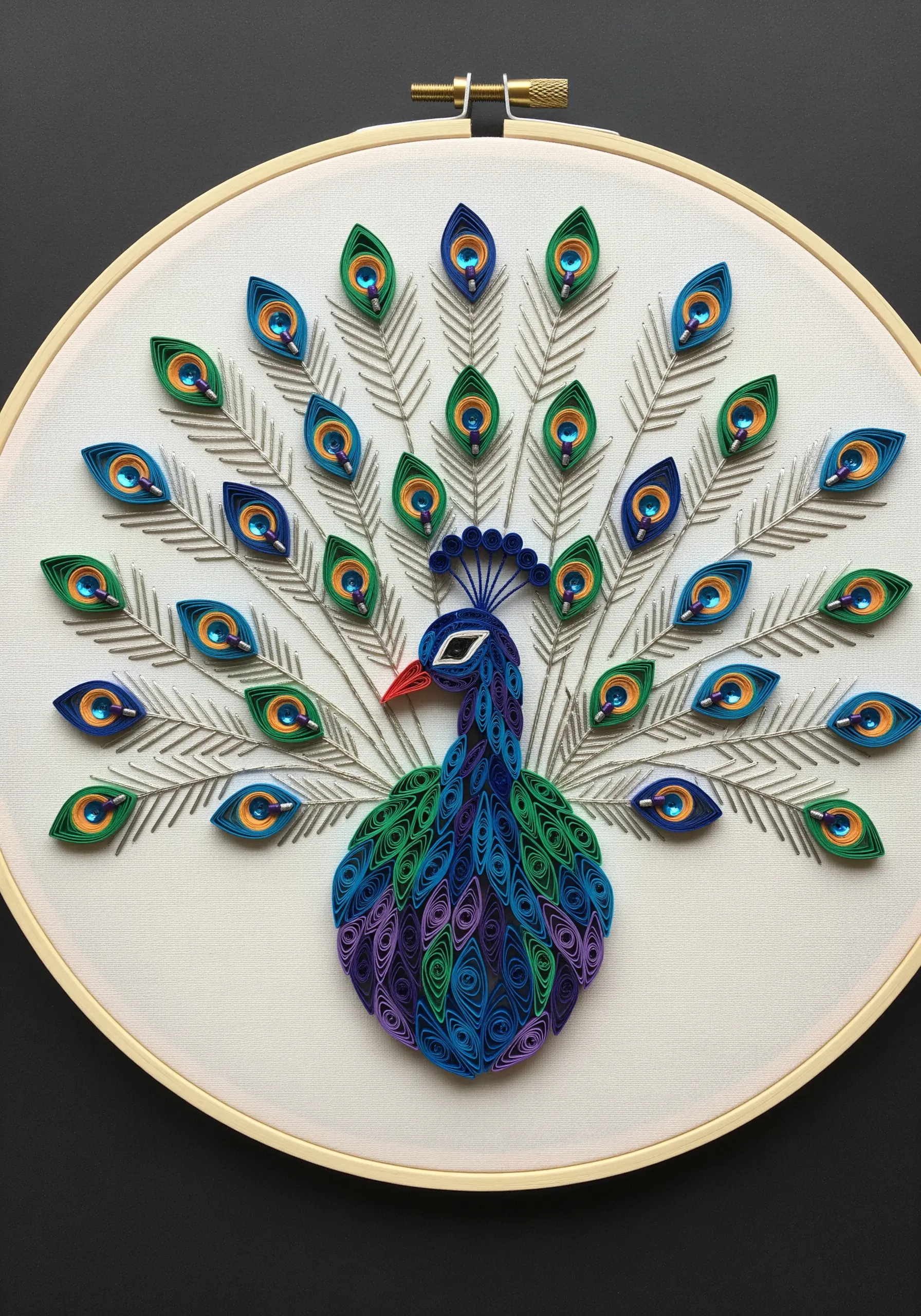 An embroidered peacock with coiled stitches mimicking paper quilling and sequins in the feathers.