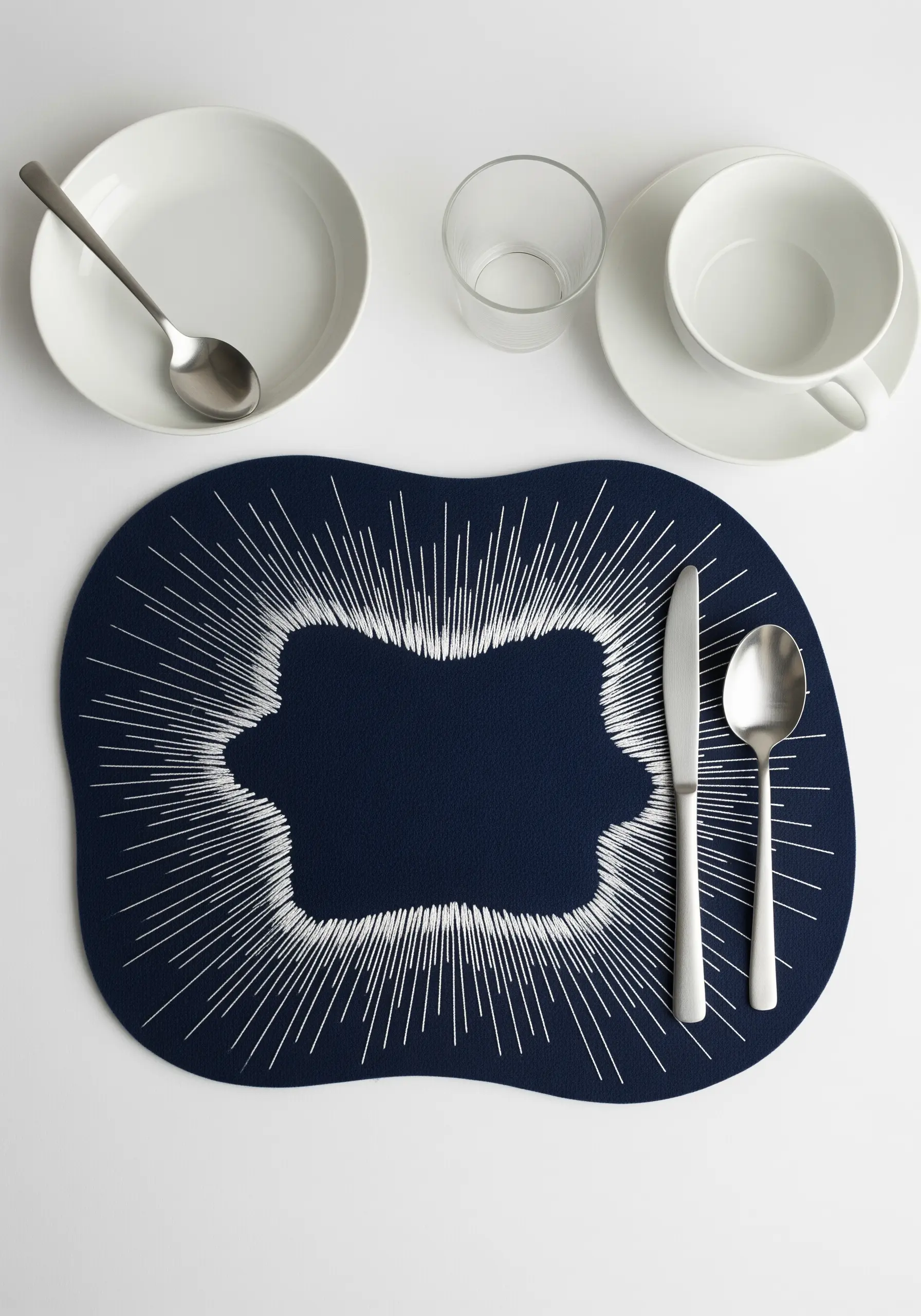 Navy placemat with white threads radiating from an empty central shape