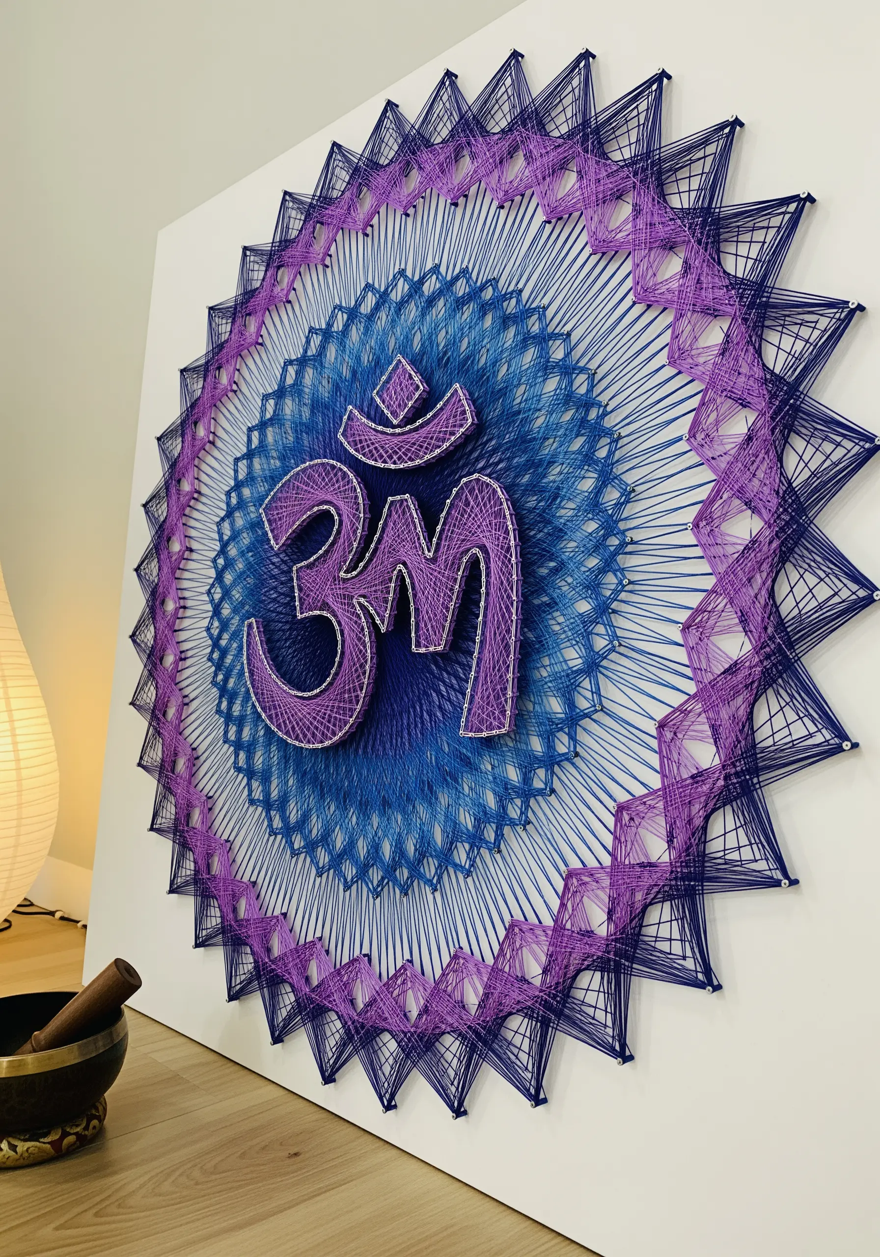 Purple and blue intricate string art mandala with Om symbol in center