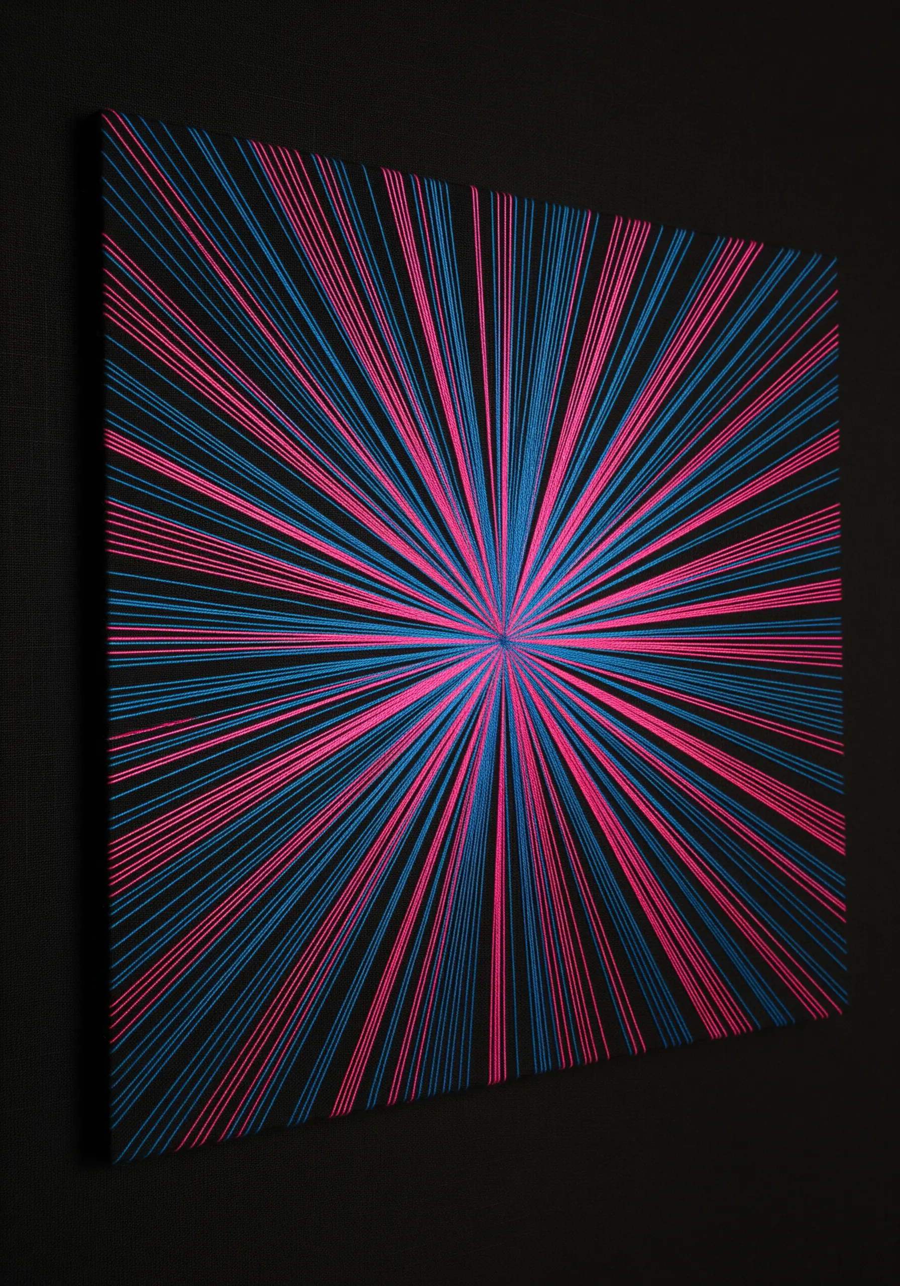 Blue and pink threads radiating from a central point on a black canvas.