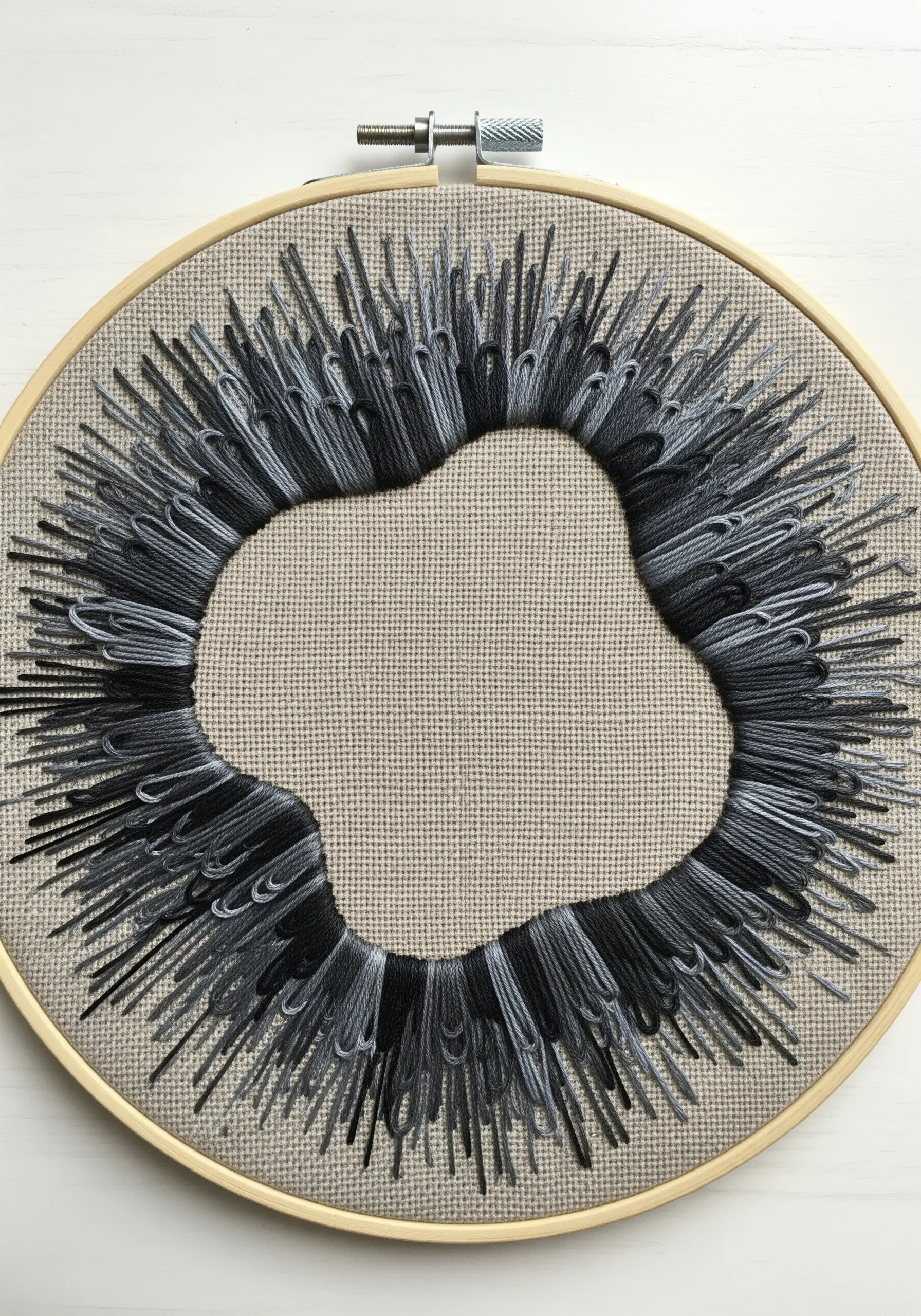 Grey and black radiating stitches forming a negative space shape