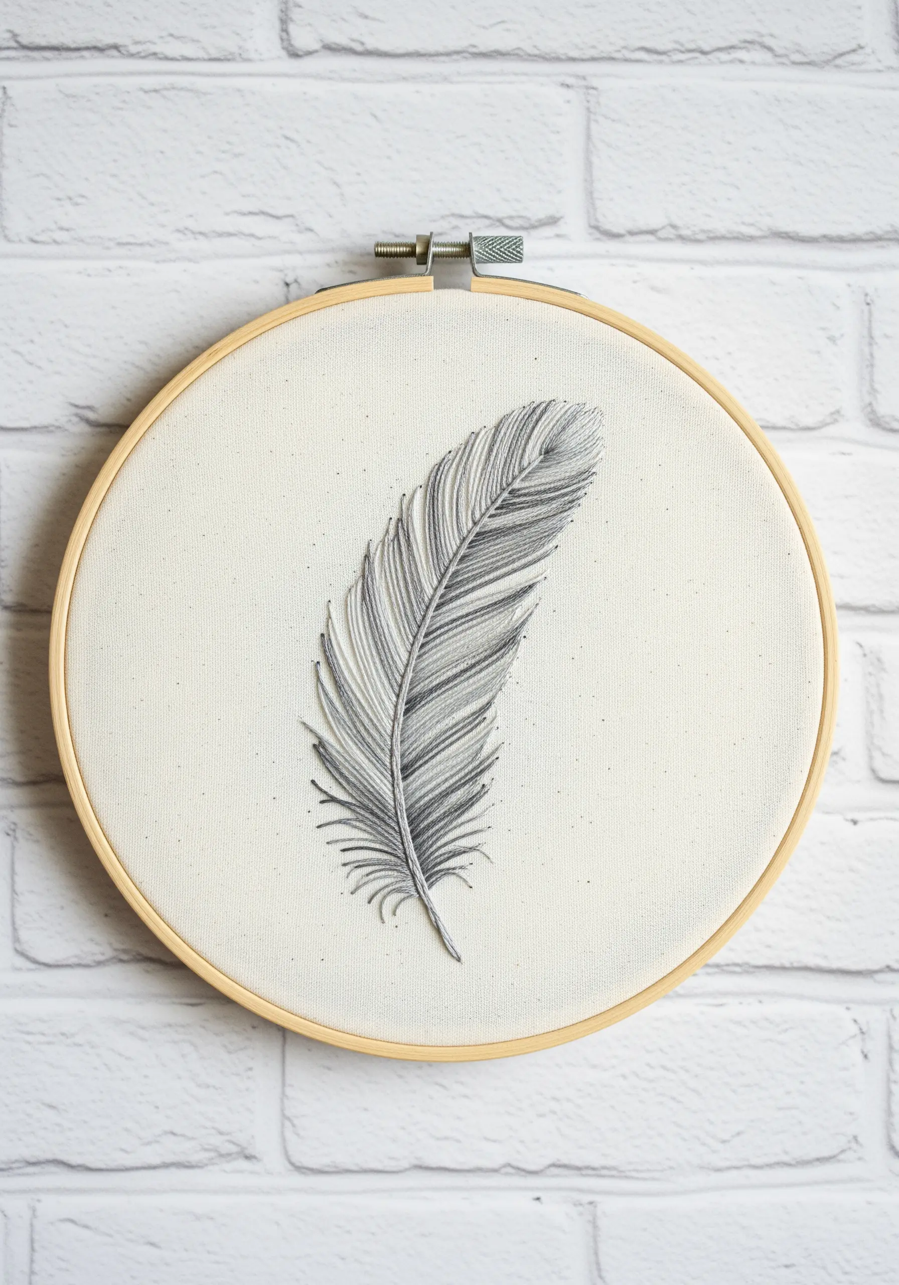 Grey scale feather embroidery on white fabric