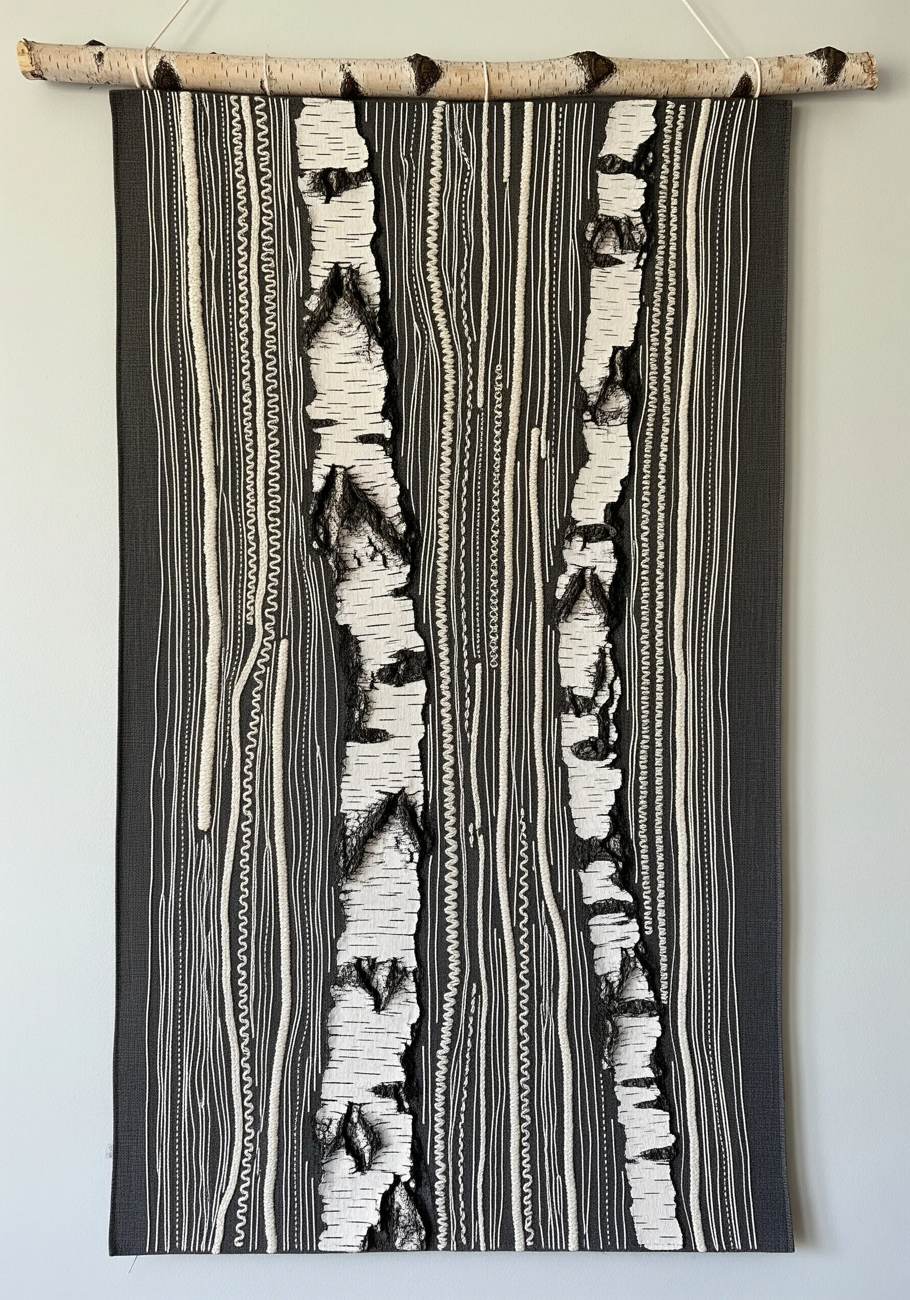 Mixed media wall hanging depicting birch trees using appliqué and black and white stitching.