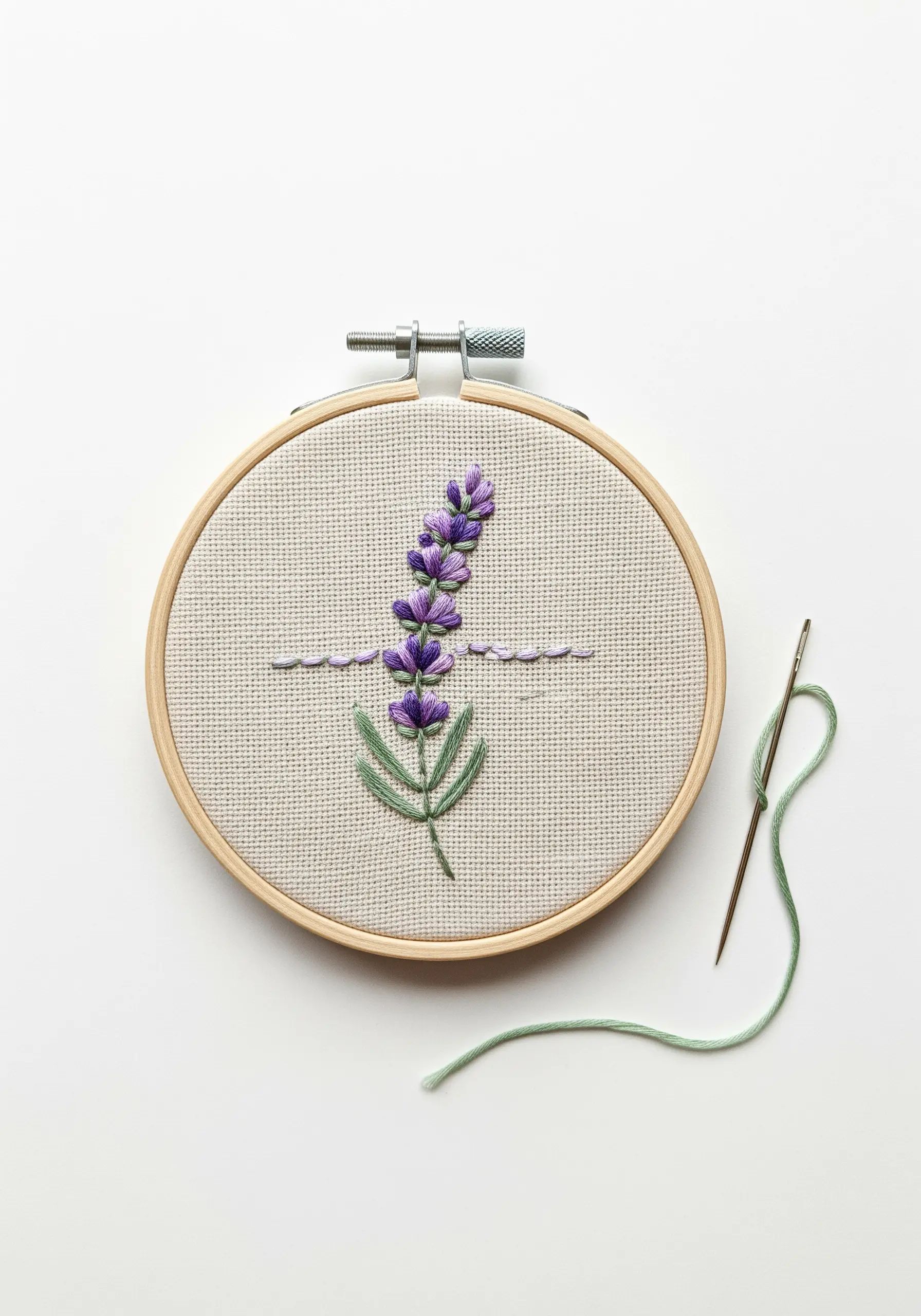 A sprig of lavender embroidered with textured purple knots and a green stem on neutral fabric.