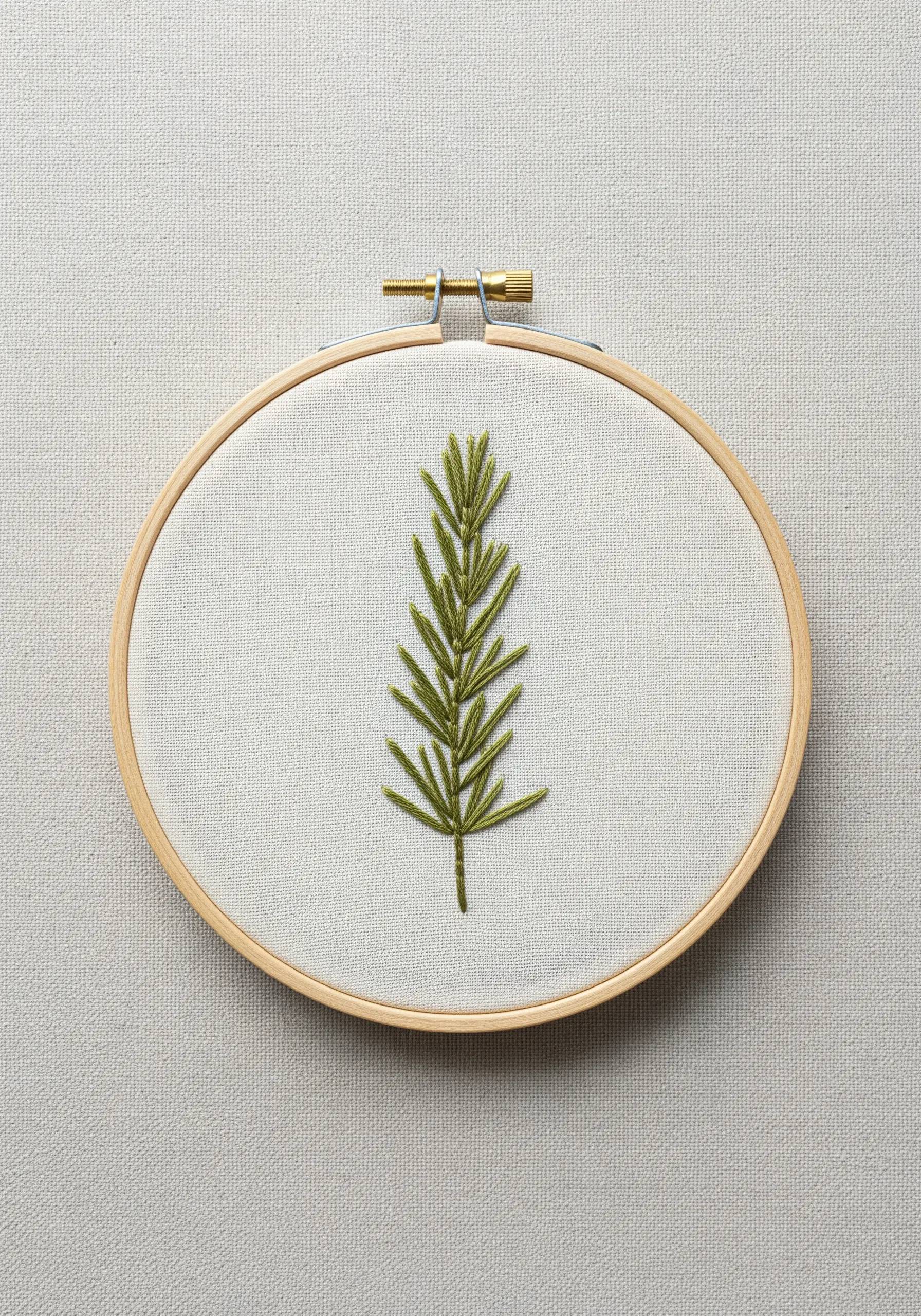 A single sprig of rosemary embroidered in olive green thread on off-white linen.