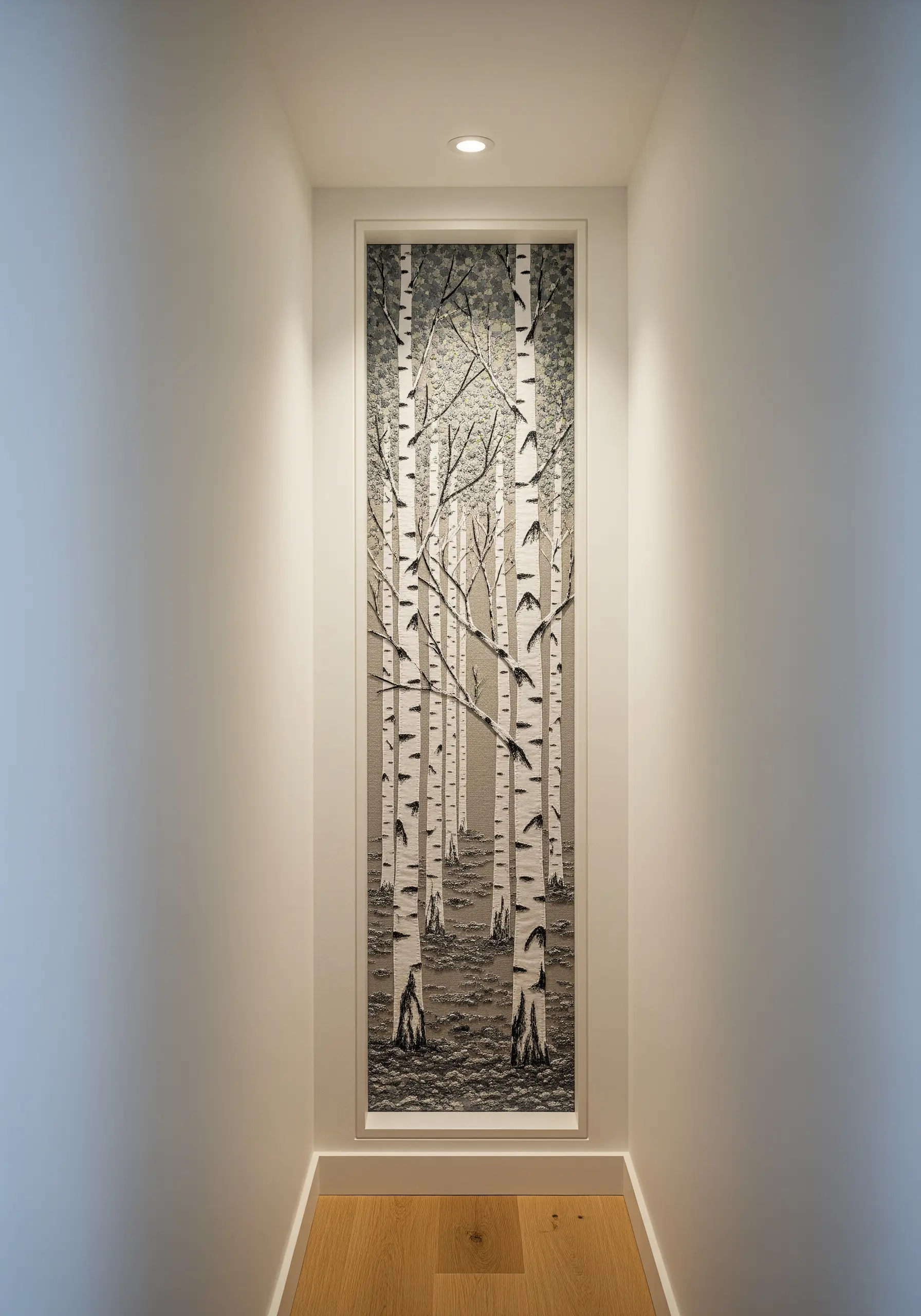 Embroidered scene of a birch tree forest in a narrow vertical wall niche in a hallway.