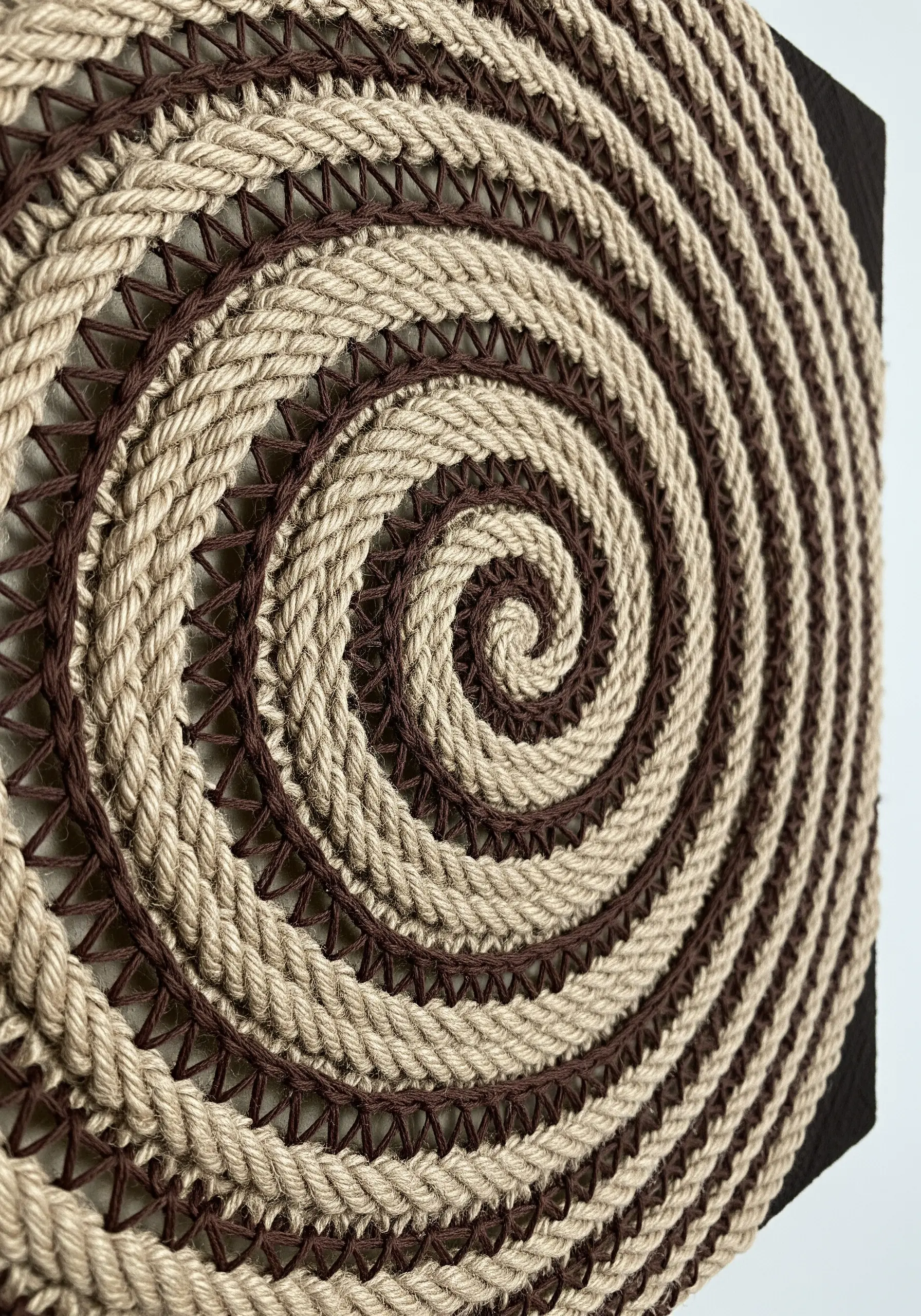 Spiral pattern made of thick jute rope on black background