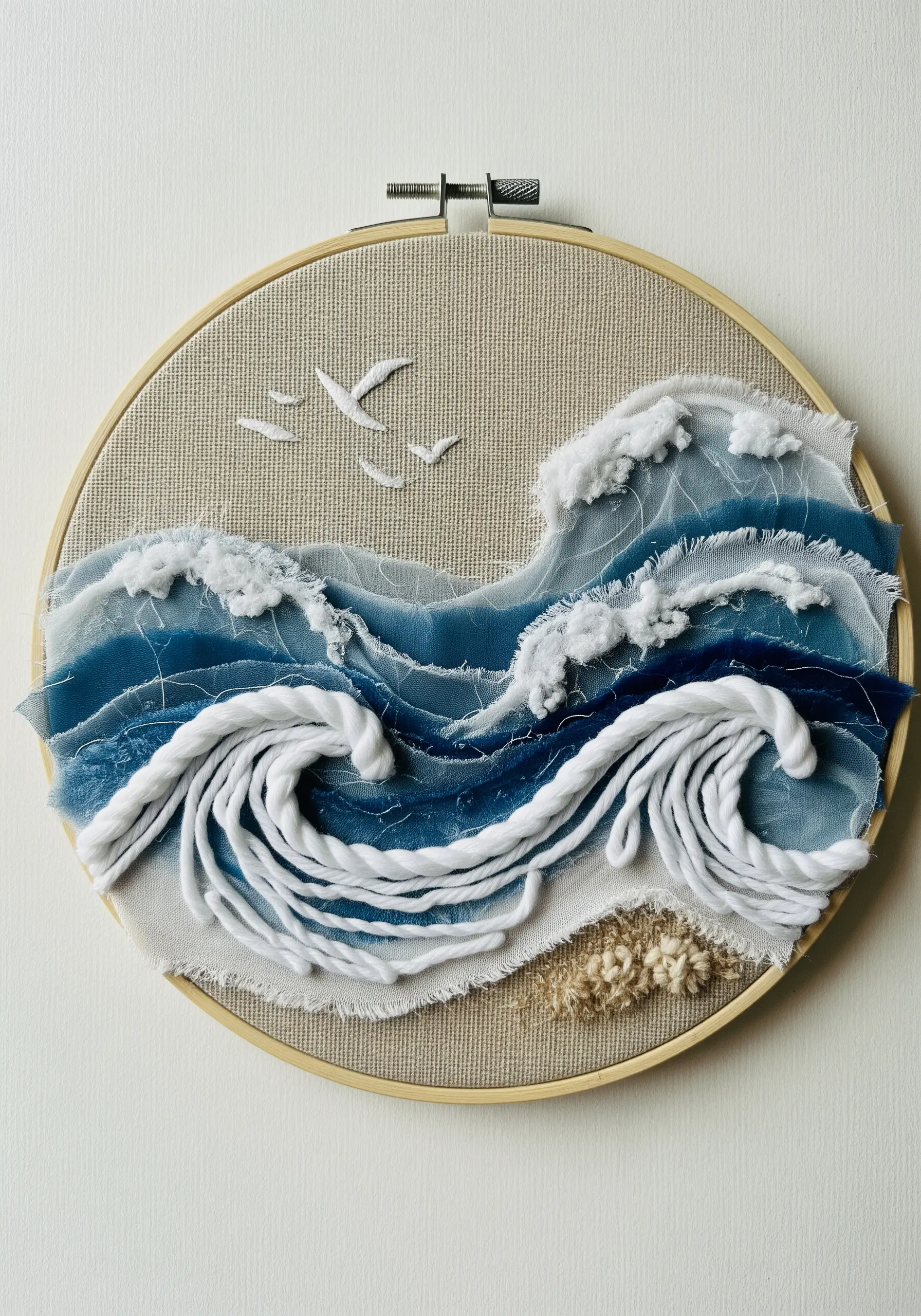 Textured ocean wave embroidery with layered fabric, couched yarn, and cotton batting foam.
