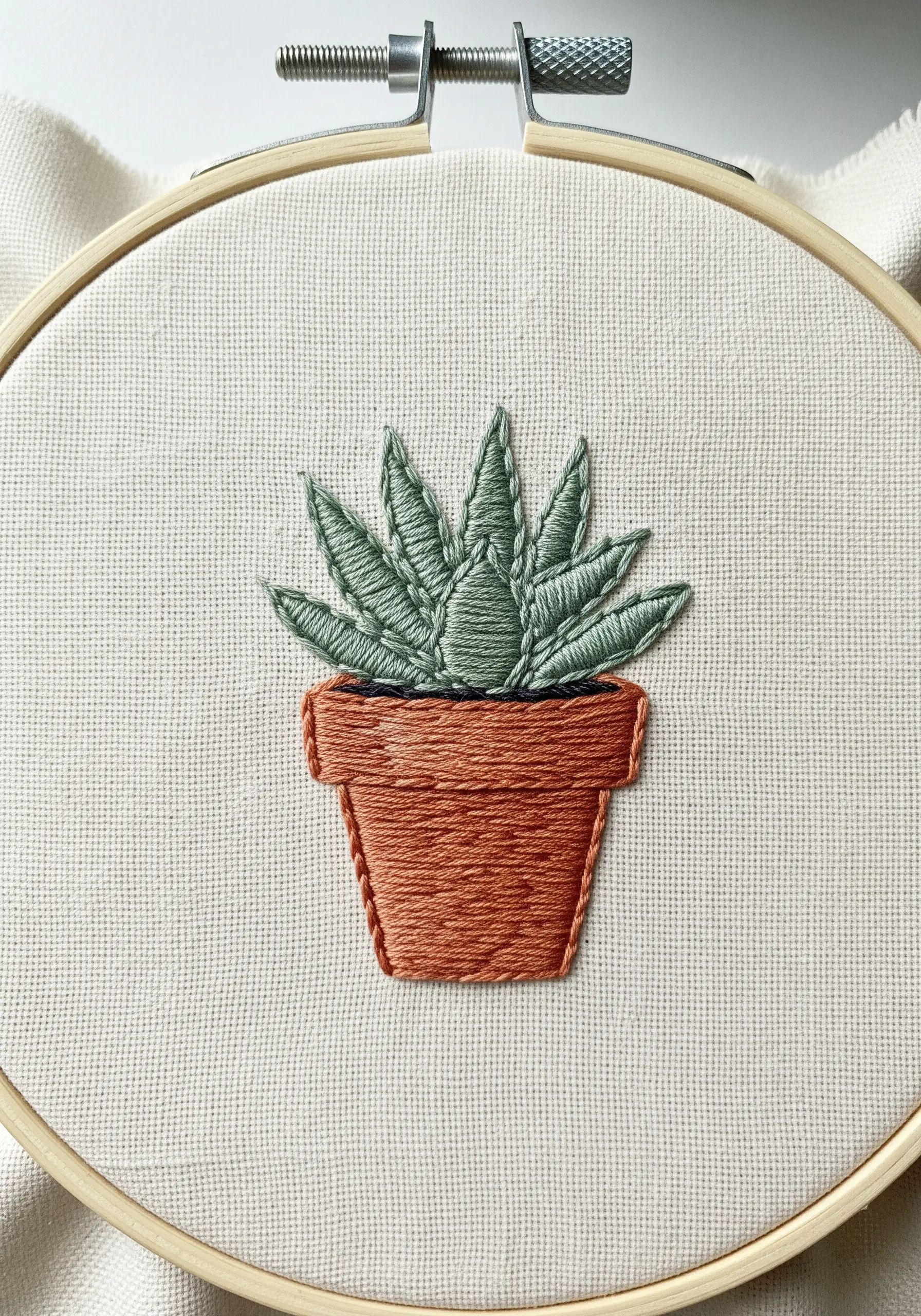 Potted succulent with textured fishbone stitch leaves and terracotta satin stitch pot.