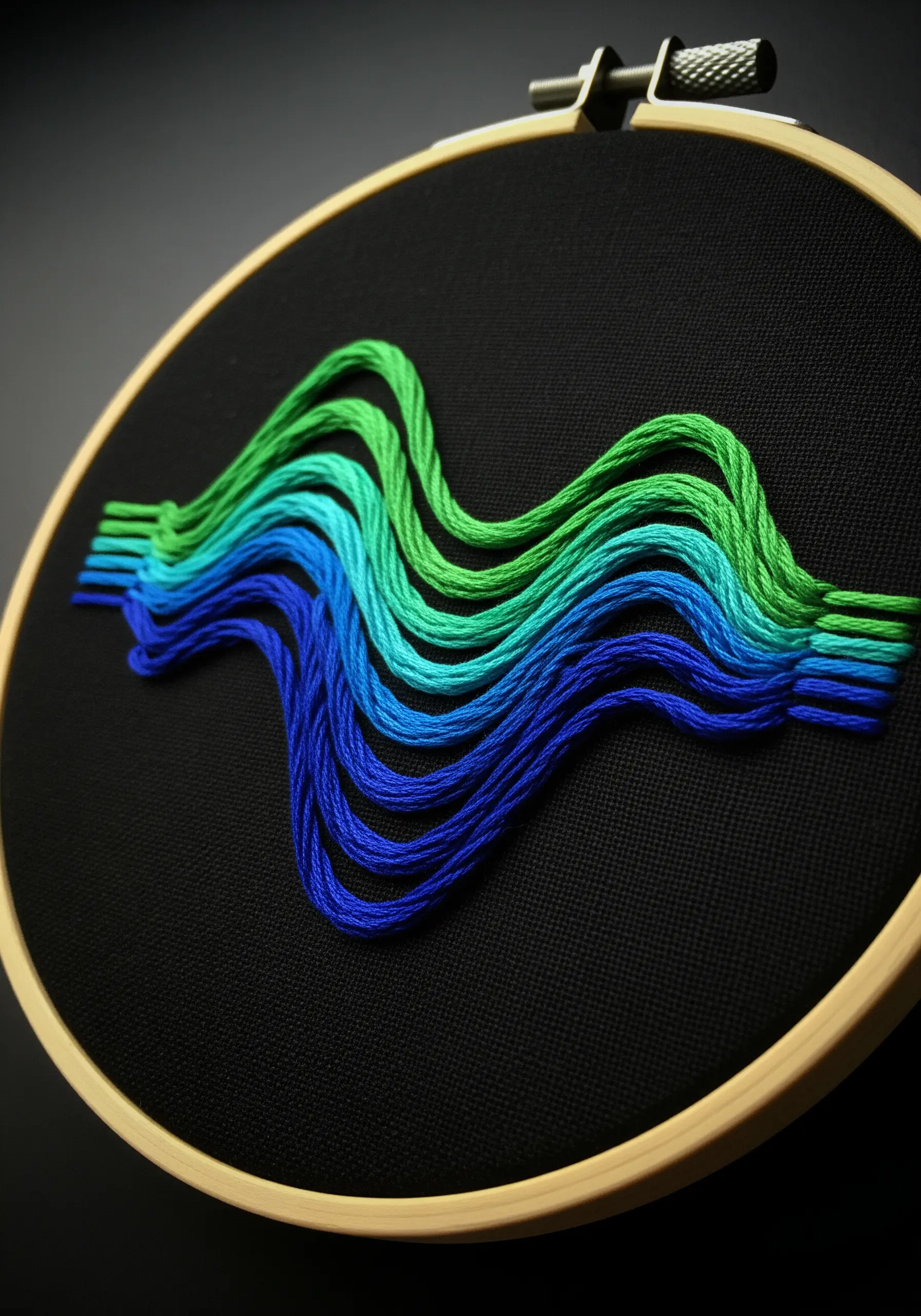 Floating, wavy lines of thread in a blue-to-green gradient on black fabric.