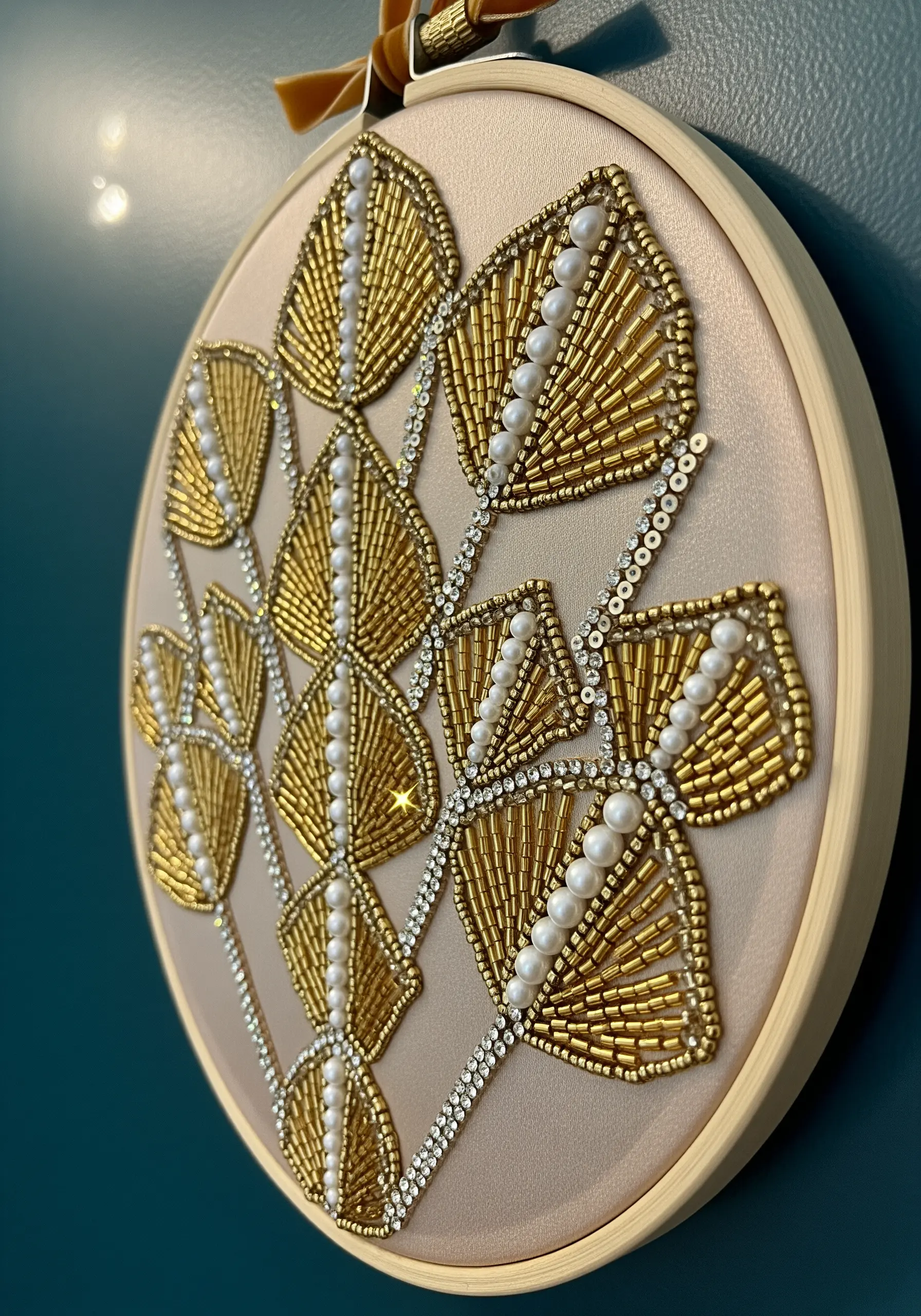 Gold beaded embroidery of art deco leaves on beige fabric