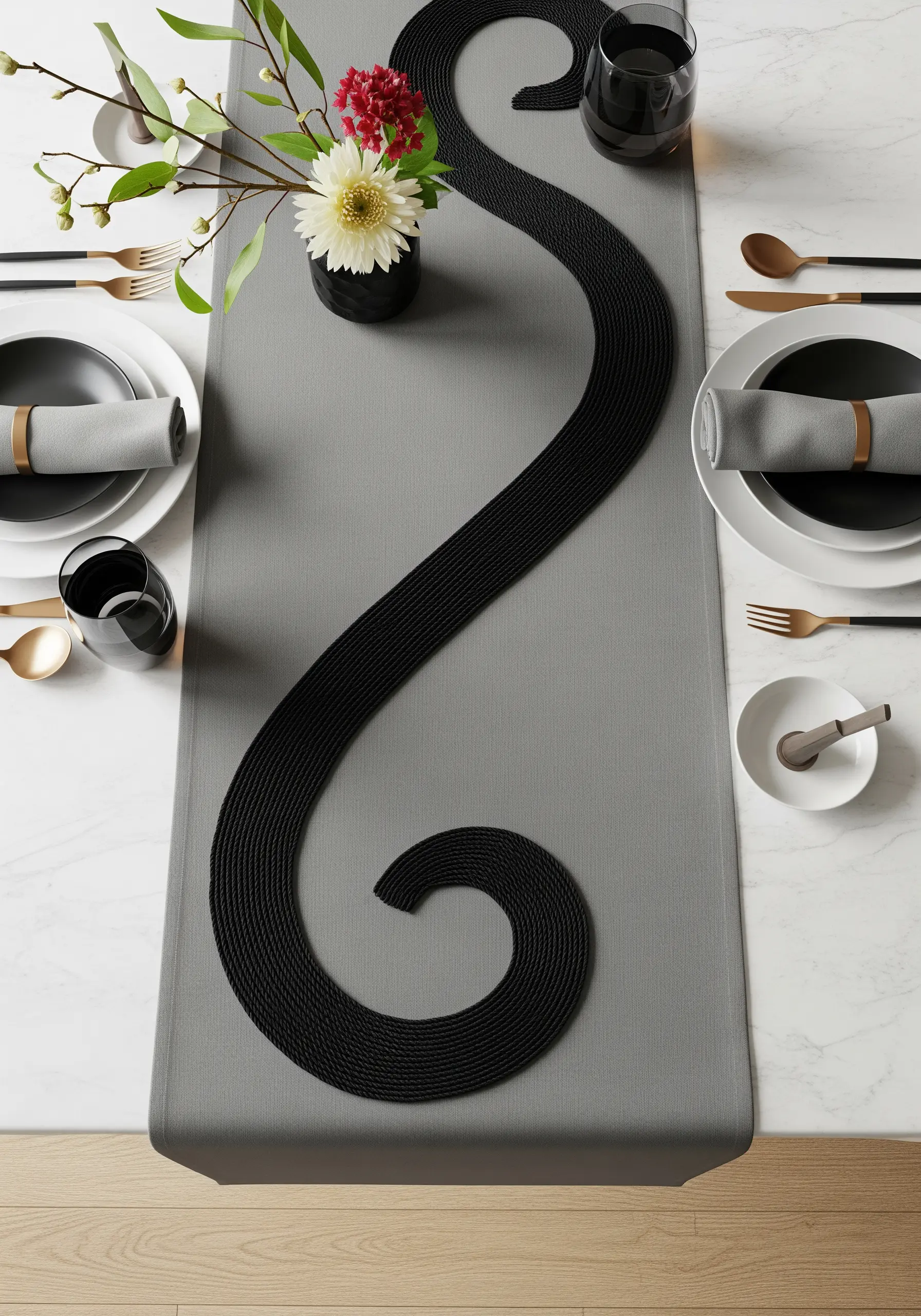 A thick, black serpentine cord design running down a grey table runner