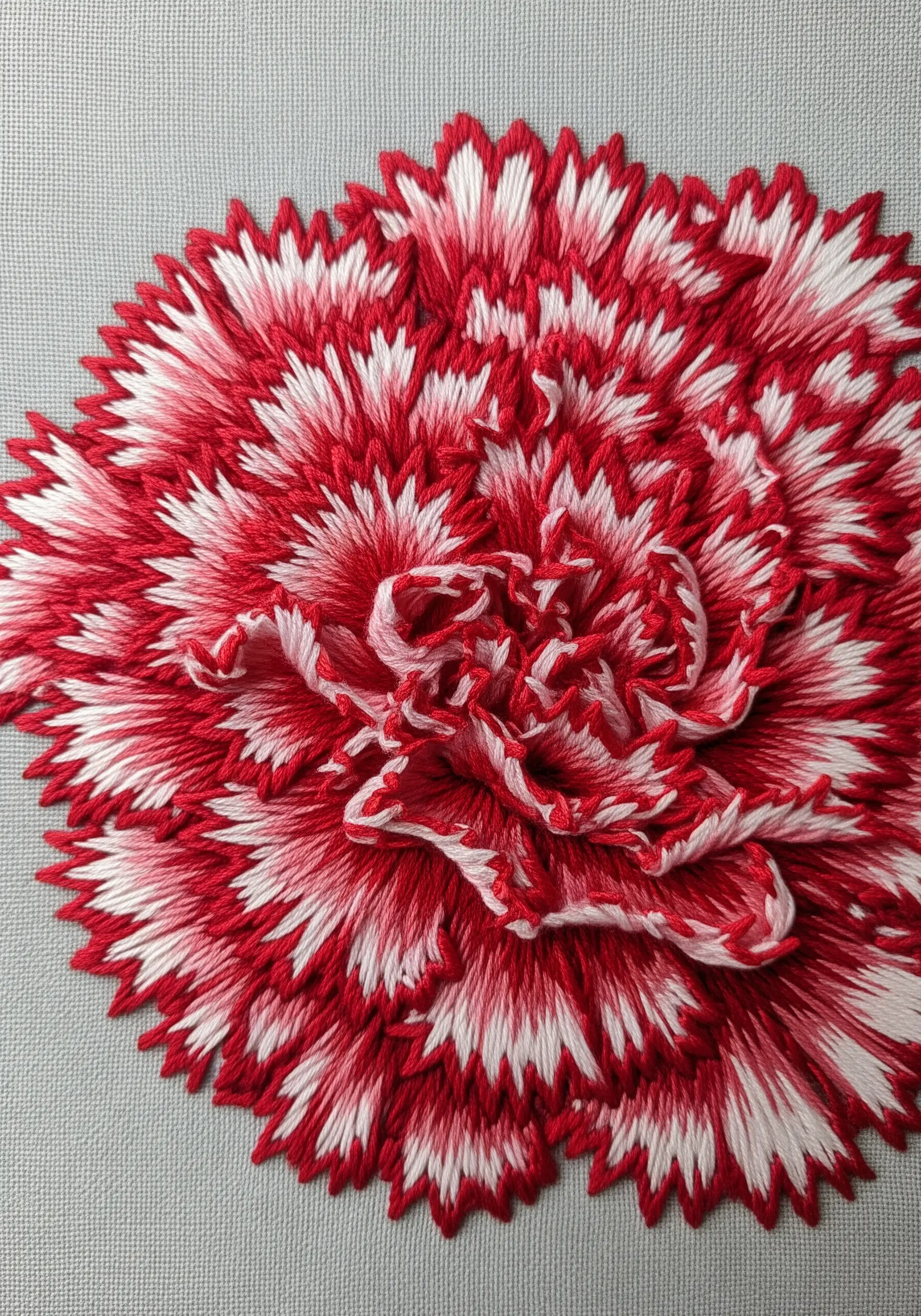 Red and white carnation embroidery featuring jagged, serrated petal edges