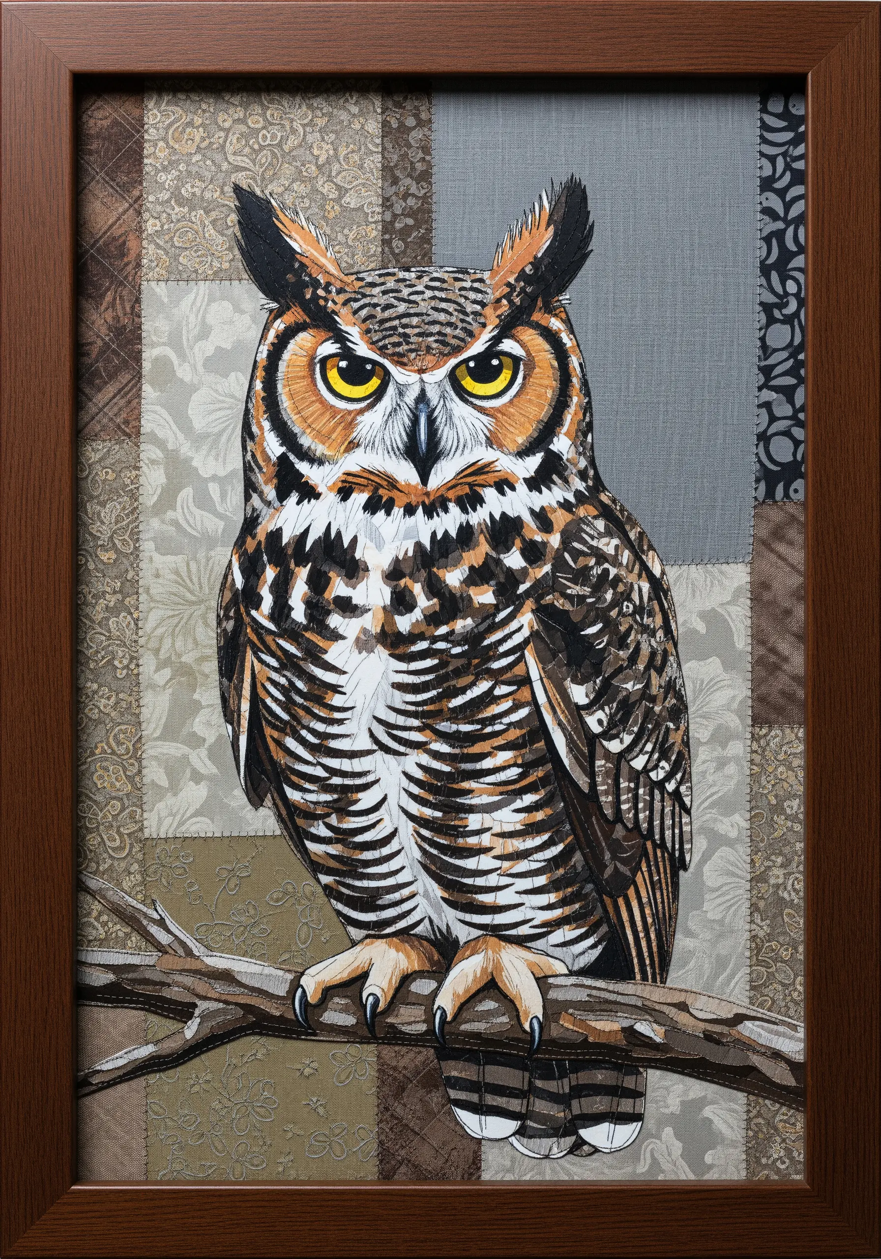 A great horned owl appliquéd onto a background made of muted, patterned patchwork squares.