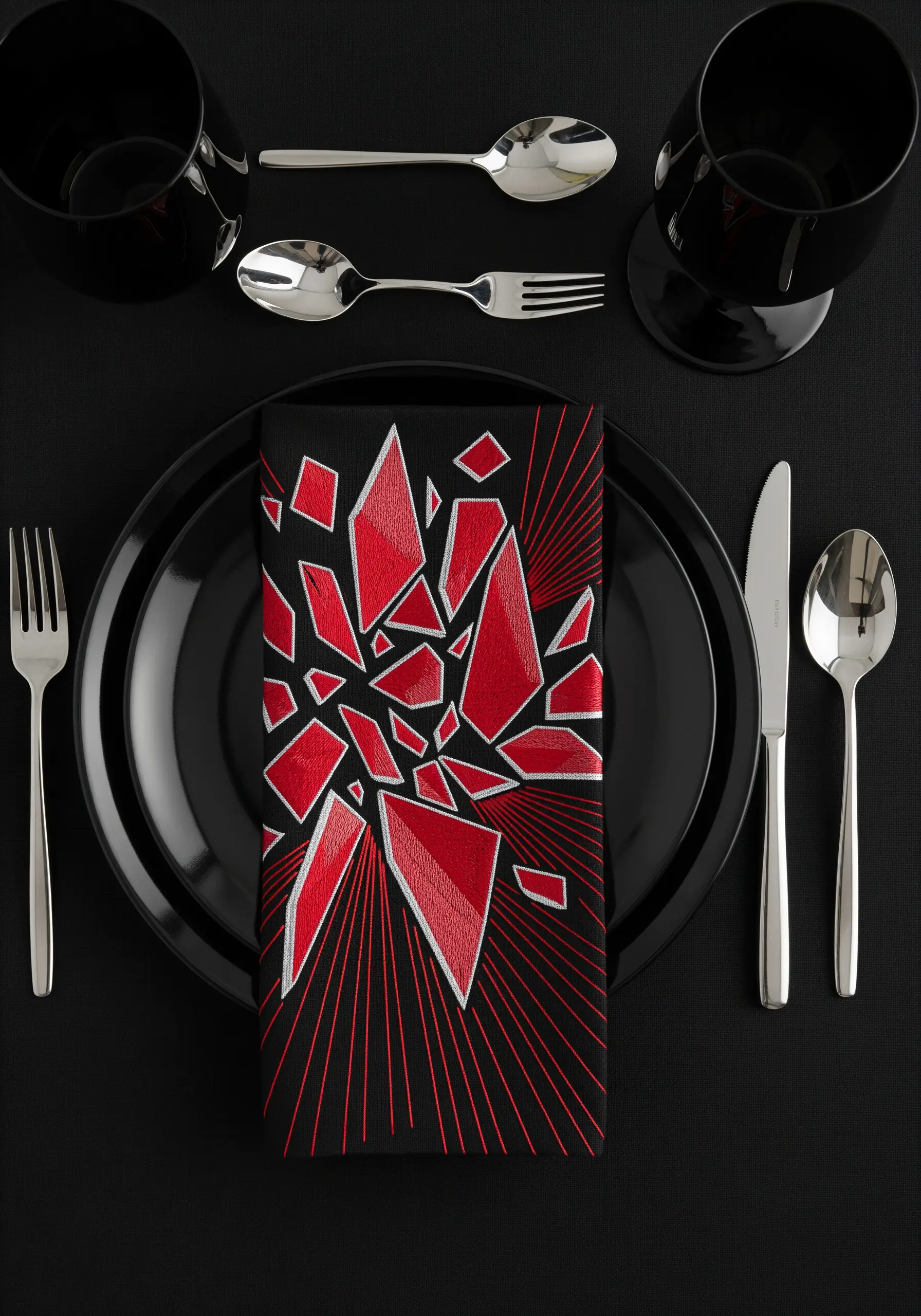 Abstract red shattered glass motif embroidered on a black napkin