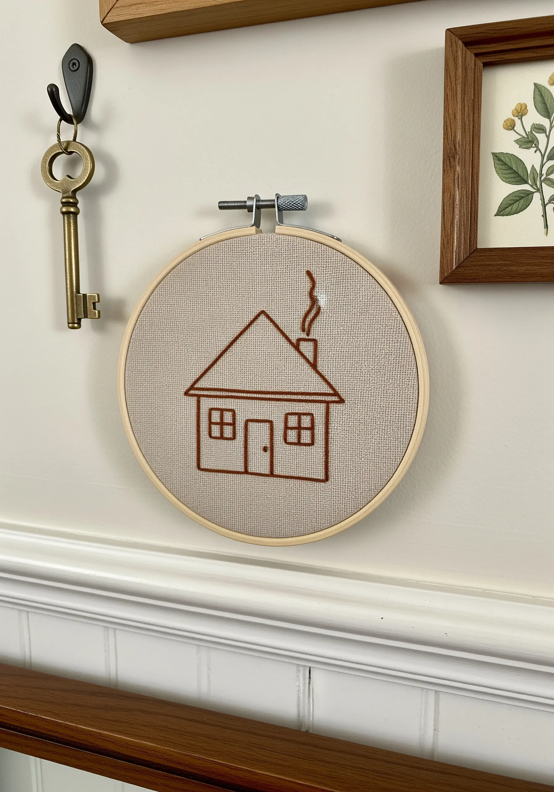 Simple brown line art embroidery of a house with smoke