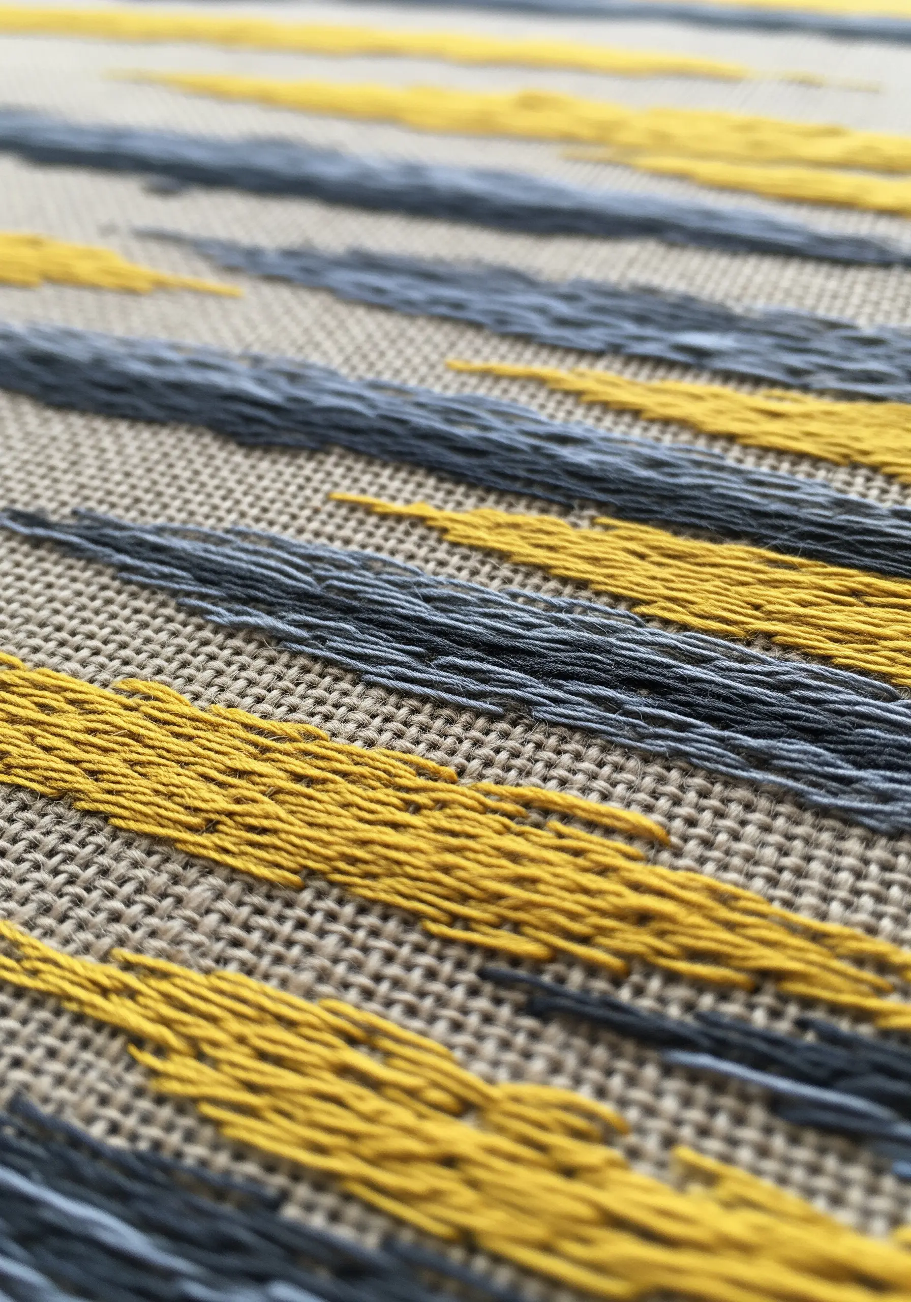 Yellow and grey abstract dash embroidery stitches on linen