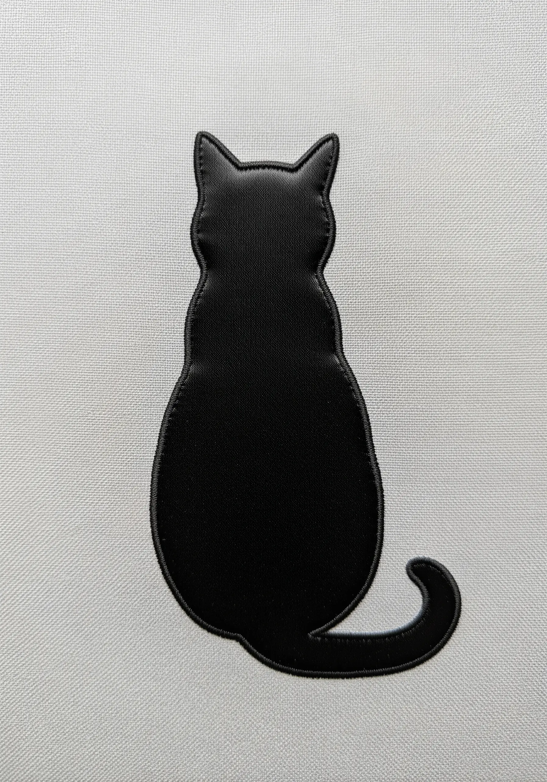 Solid black cat silhouette embroidery on light grey fabric
