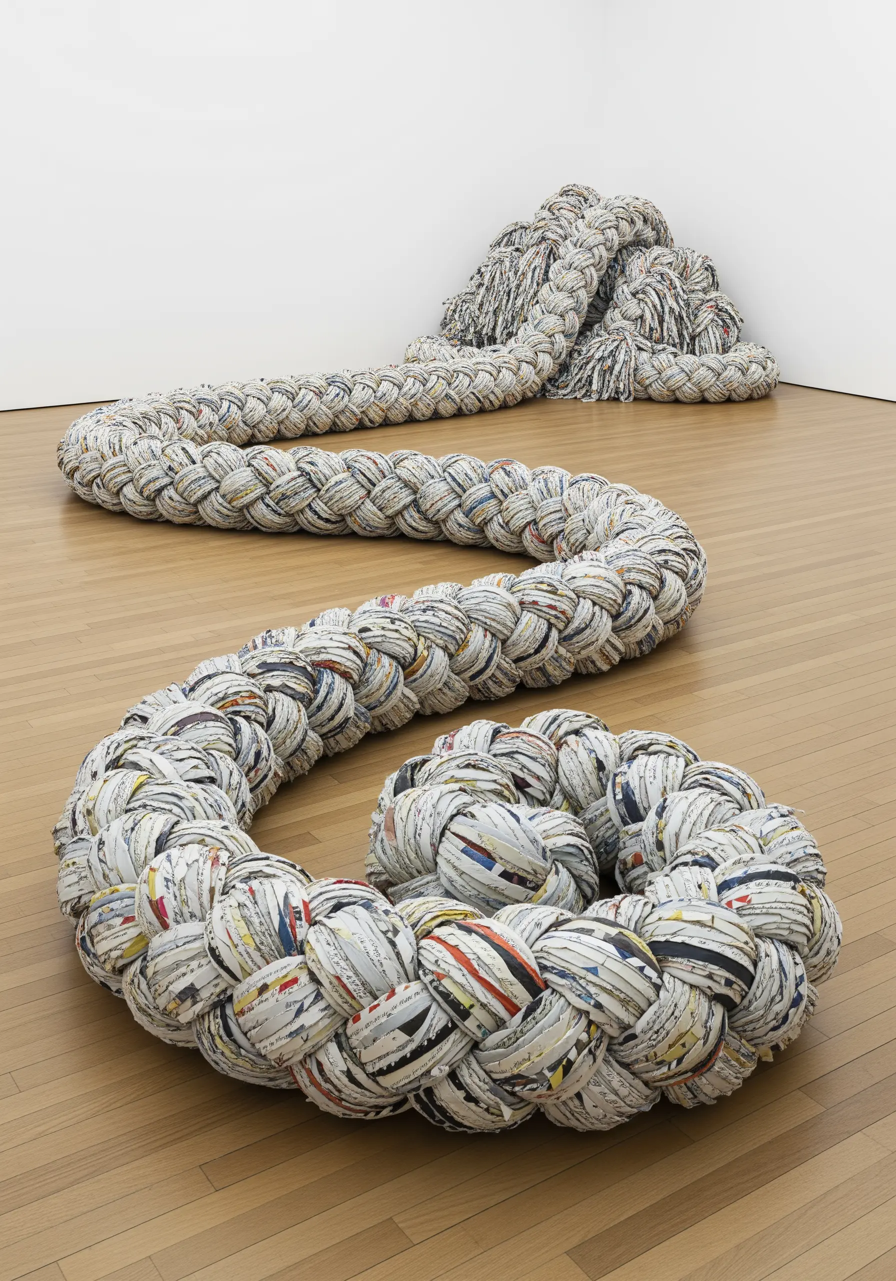 A giant, serpentine rope braided from thousands of strips of twisted newspaper.