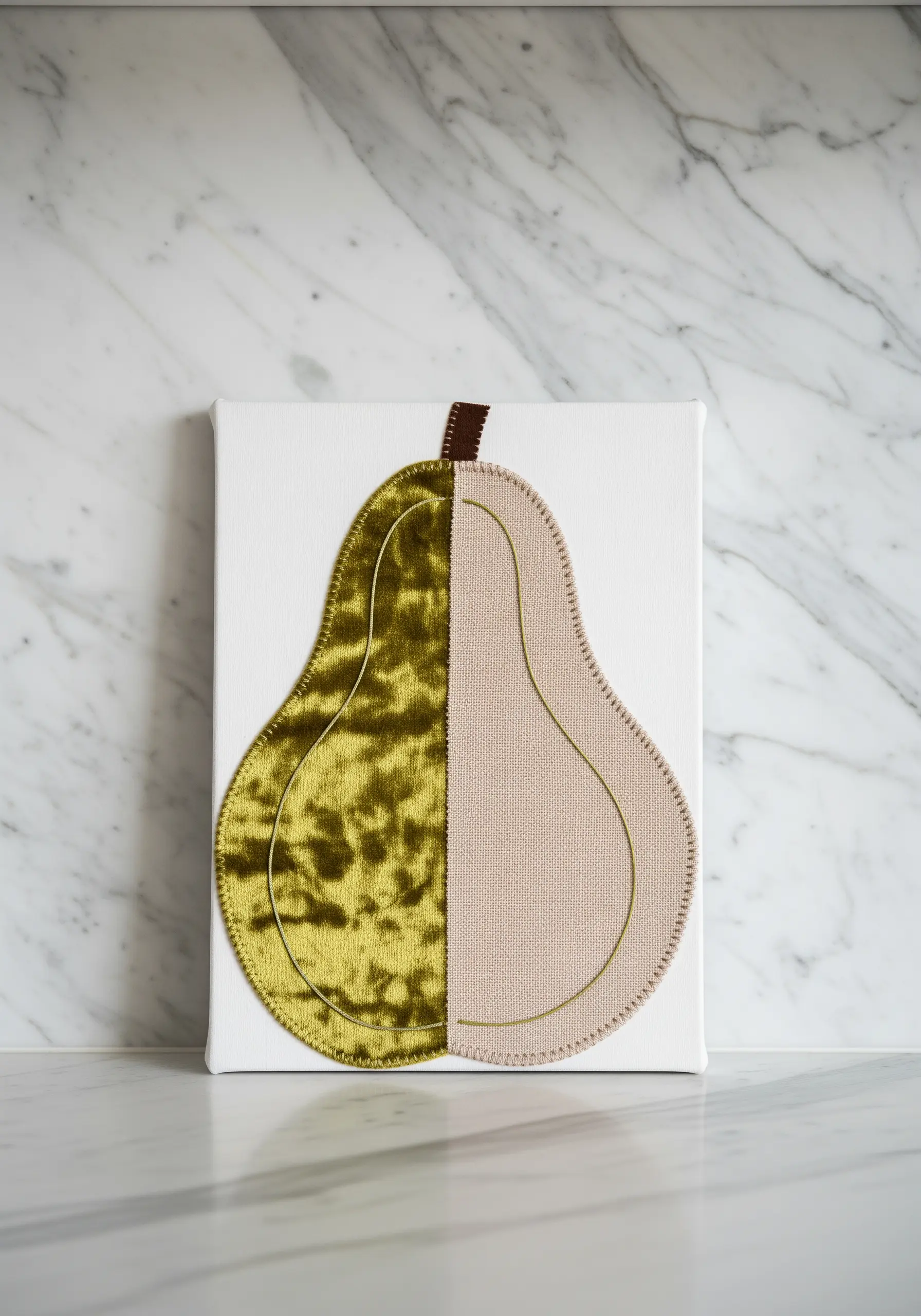 A pear appliqué made of two contrasting fabrics: olive green velvet and neutral linen.