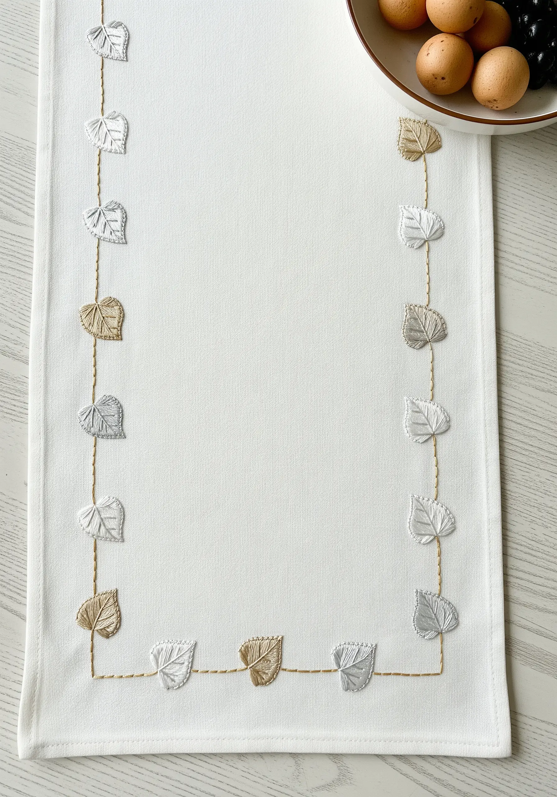 A simple table runner border of tiny leaves connected by a delicate golden thread.