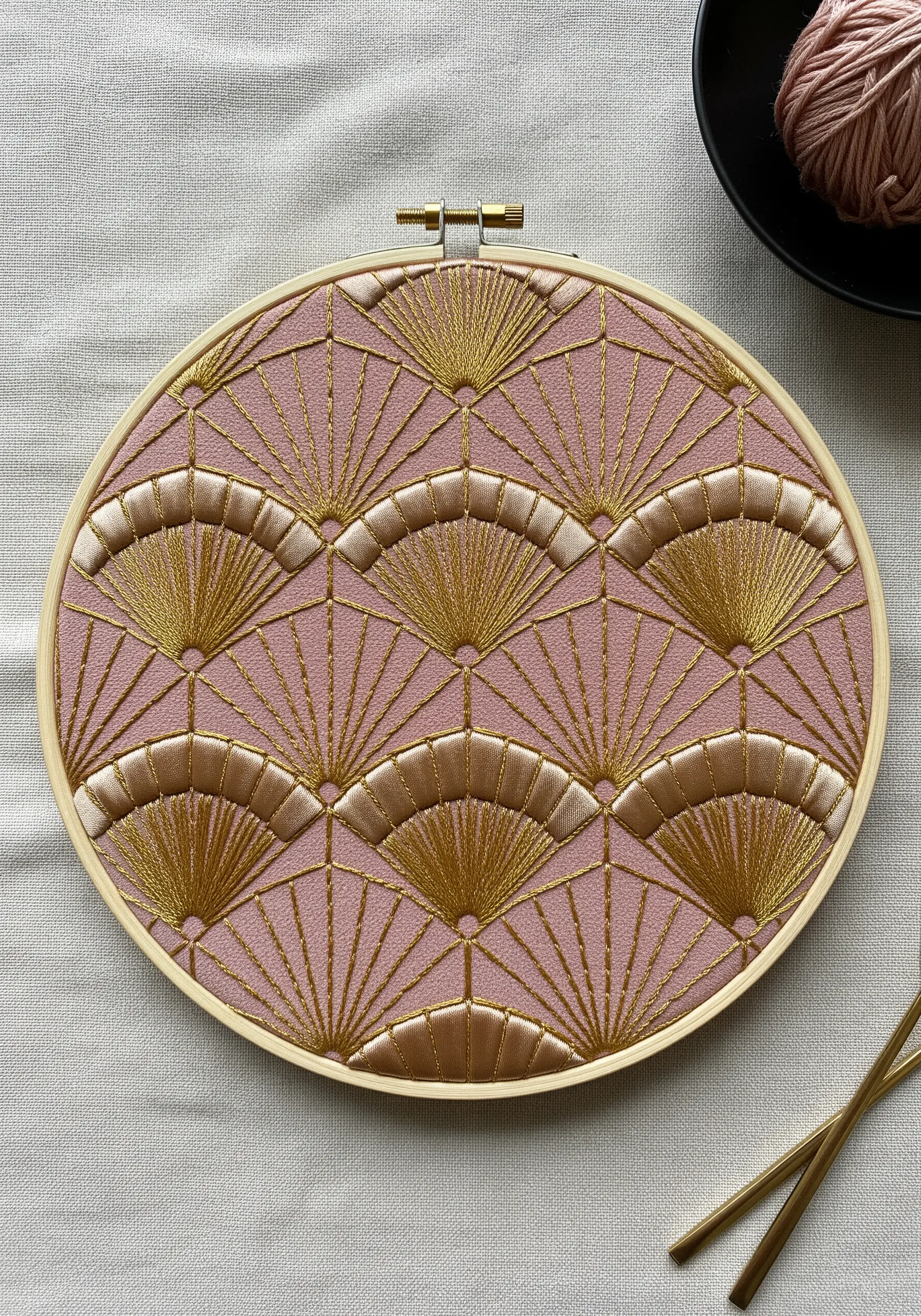 Art Deco fan pattern embroidered in gold and cream metallic threads on pink fabric.