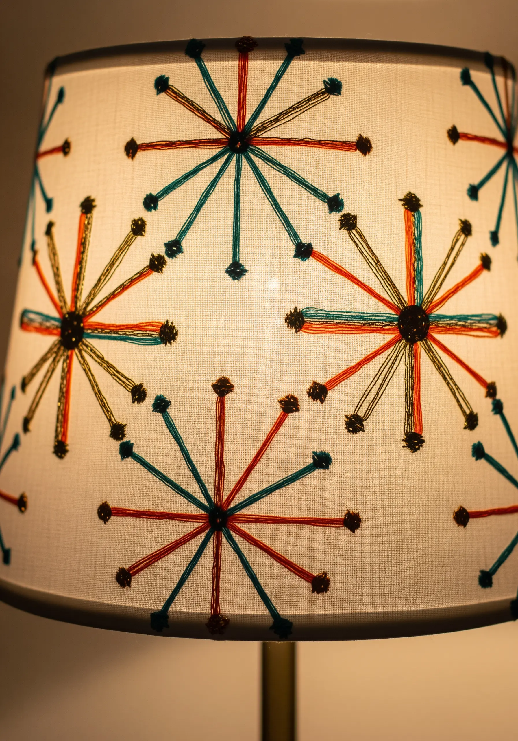 A mid-century modern starburst pattern stitched directly onto a fabric lampshade.
