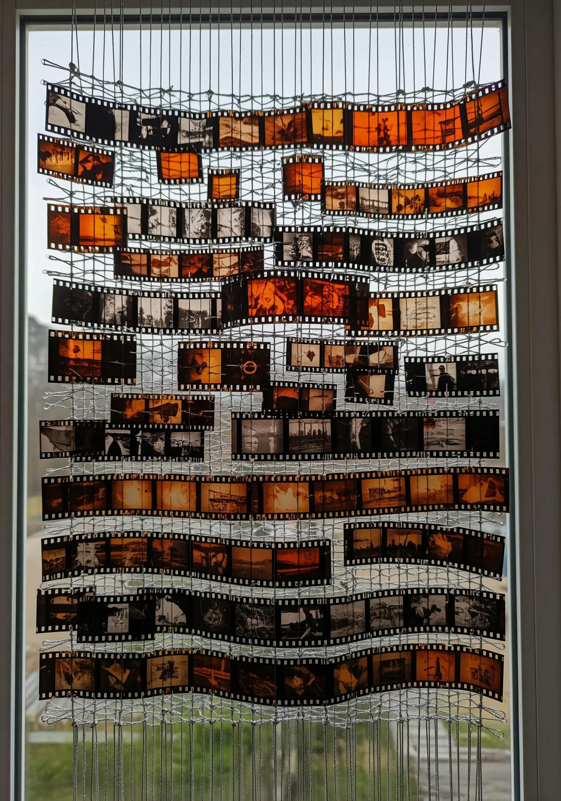 Curtain made of stitched-together film negatives hanging in a window