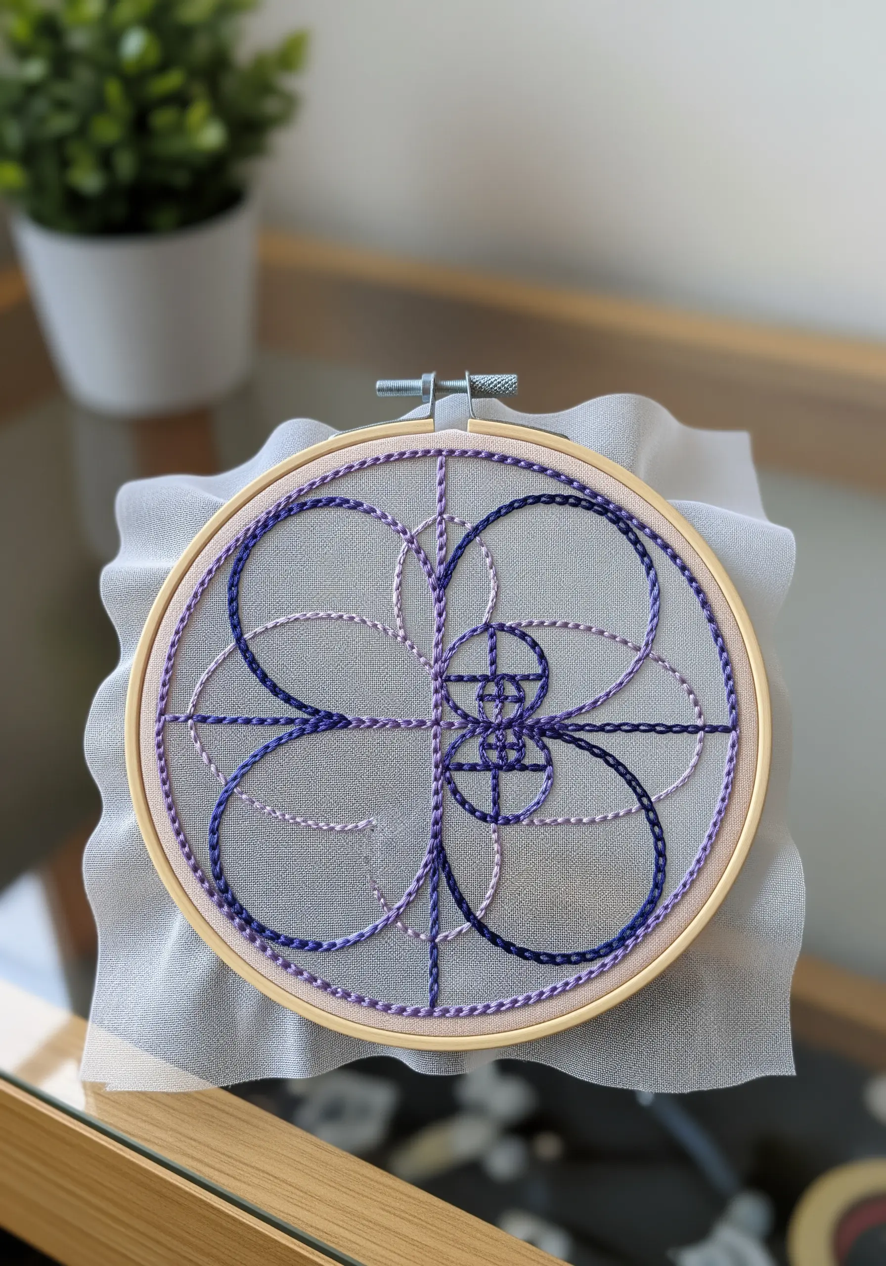 Fibonacci spiral embroidered in purple and blue variegated chain stitch.