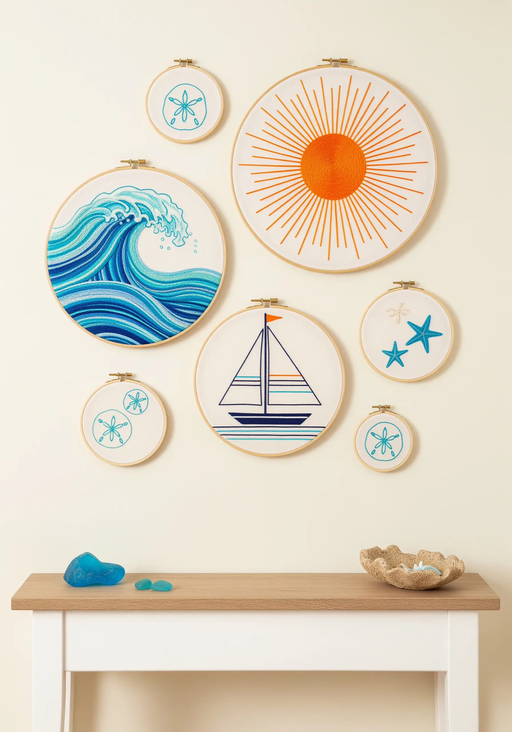 Coastal-themed embroidery hoop art with a wave, sun, sailboat, and starfish.