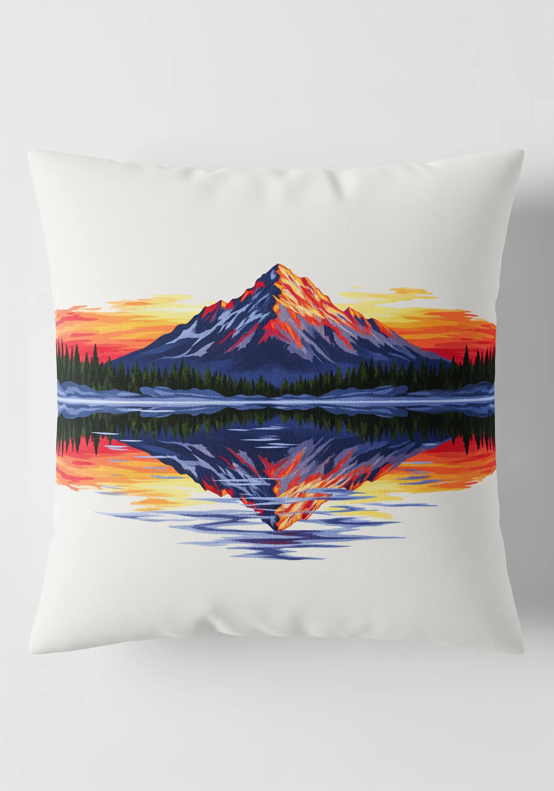 Pillow with an embroidered mountain and its perfect reflection in a lake at sunset.