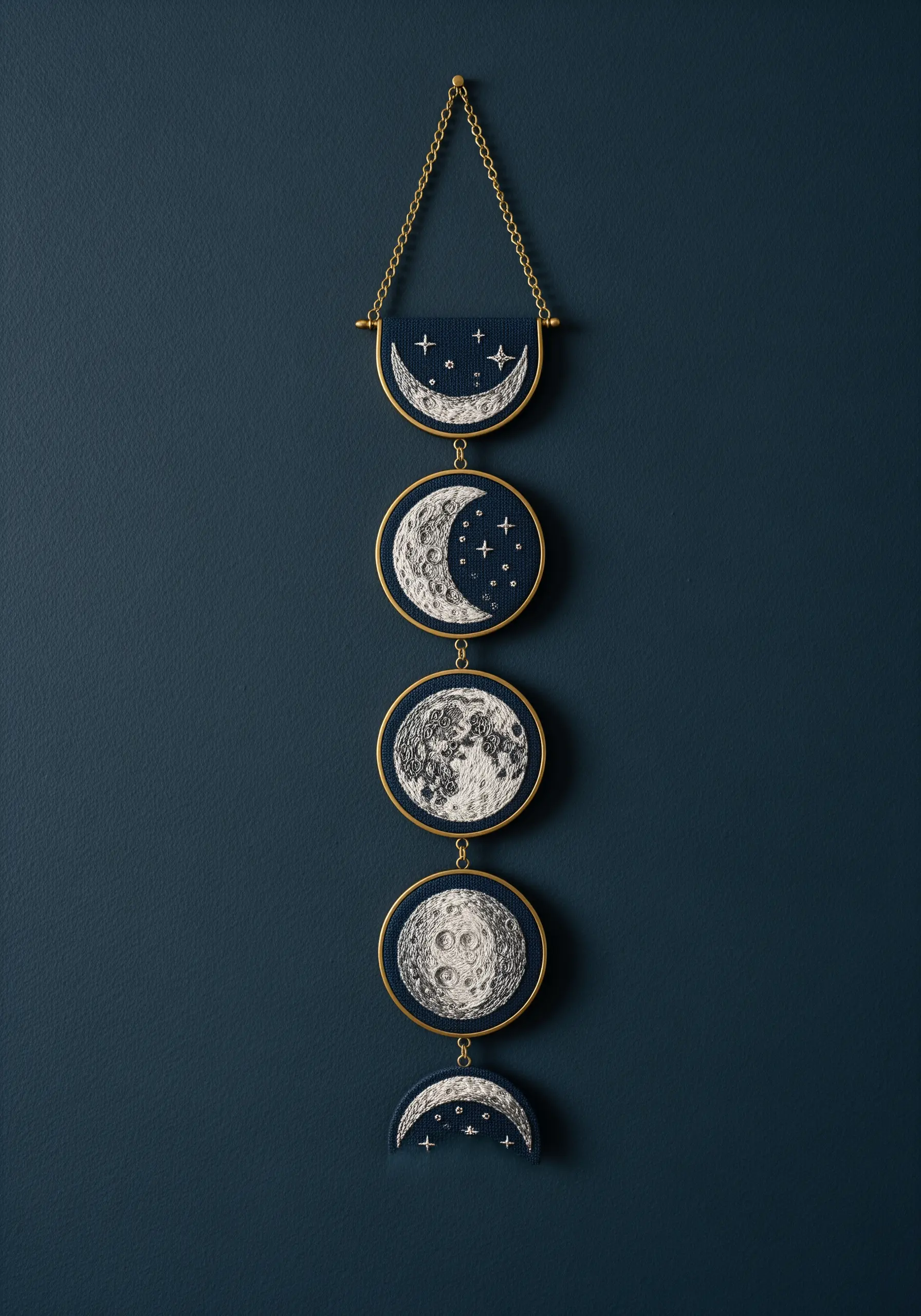 A vertical wall hanging of embroidered moon phases, each in its own small, dark hoop.
