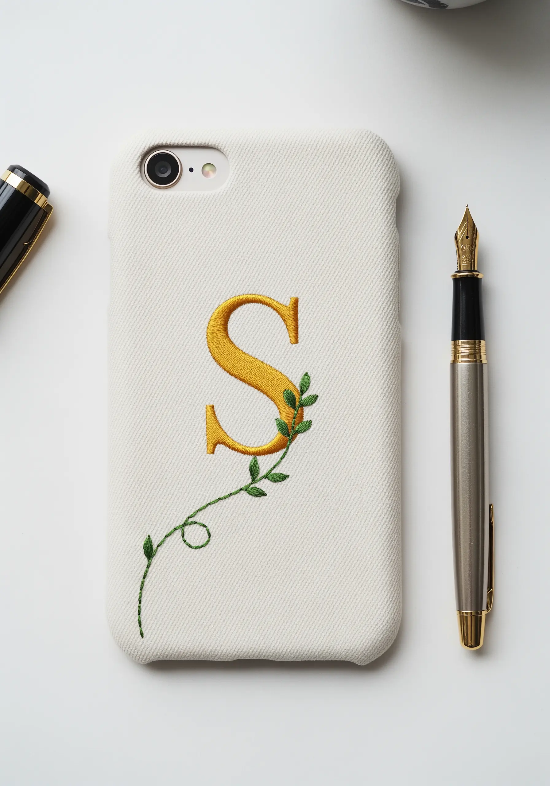 A golden yellow initial 'S' with a delicate green vine wrapped around it.