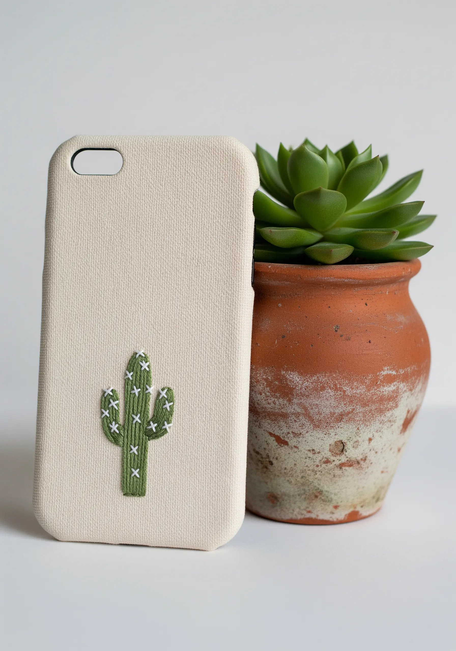 A green satin-stitched saguaro cactus with small white stitches for spines.