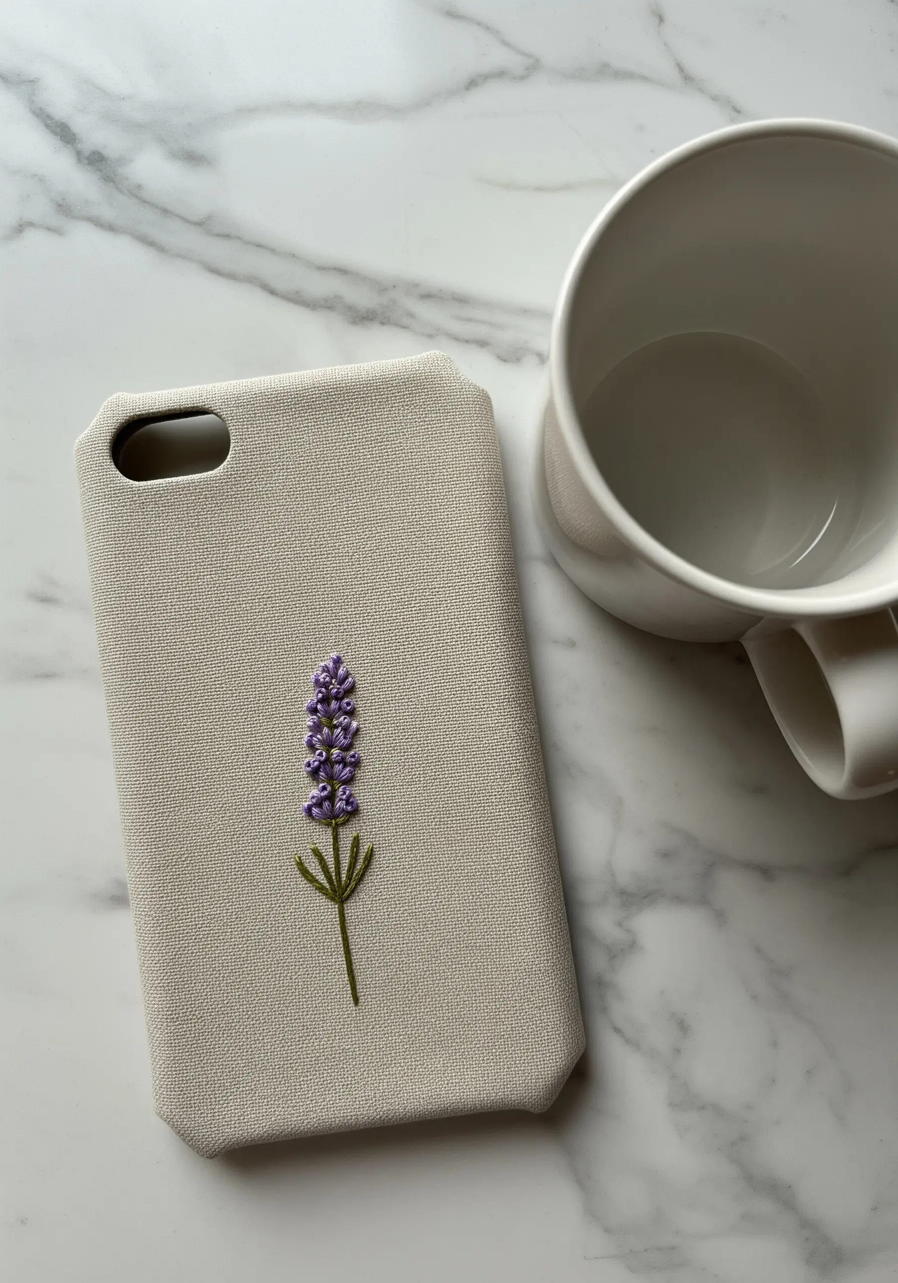 A single lavender sprig embroidered with purple French knots on a light-colored phone case.