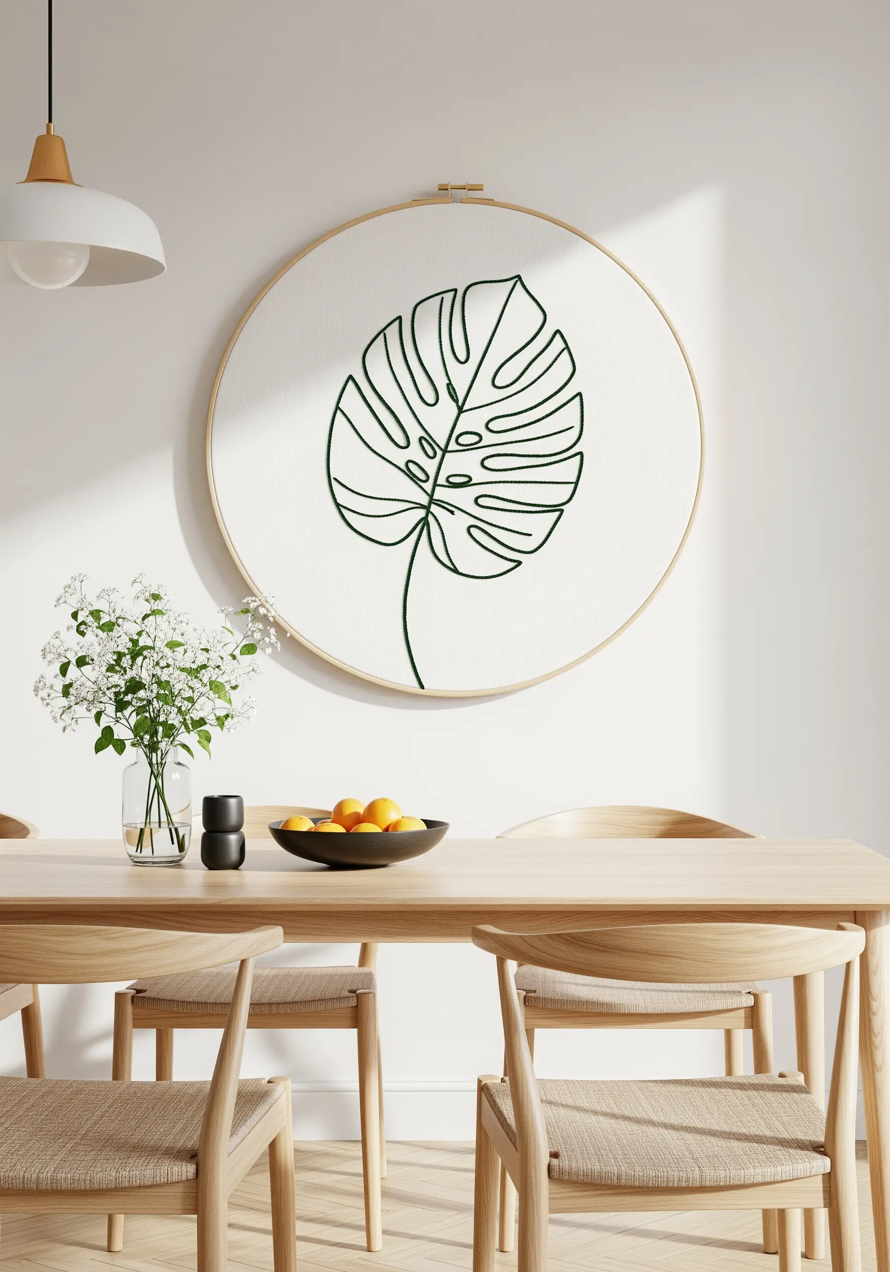 Large embroidery hoop with a single-line Monstera leaf stitched in green thread.