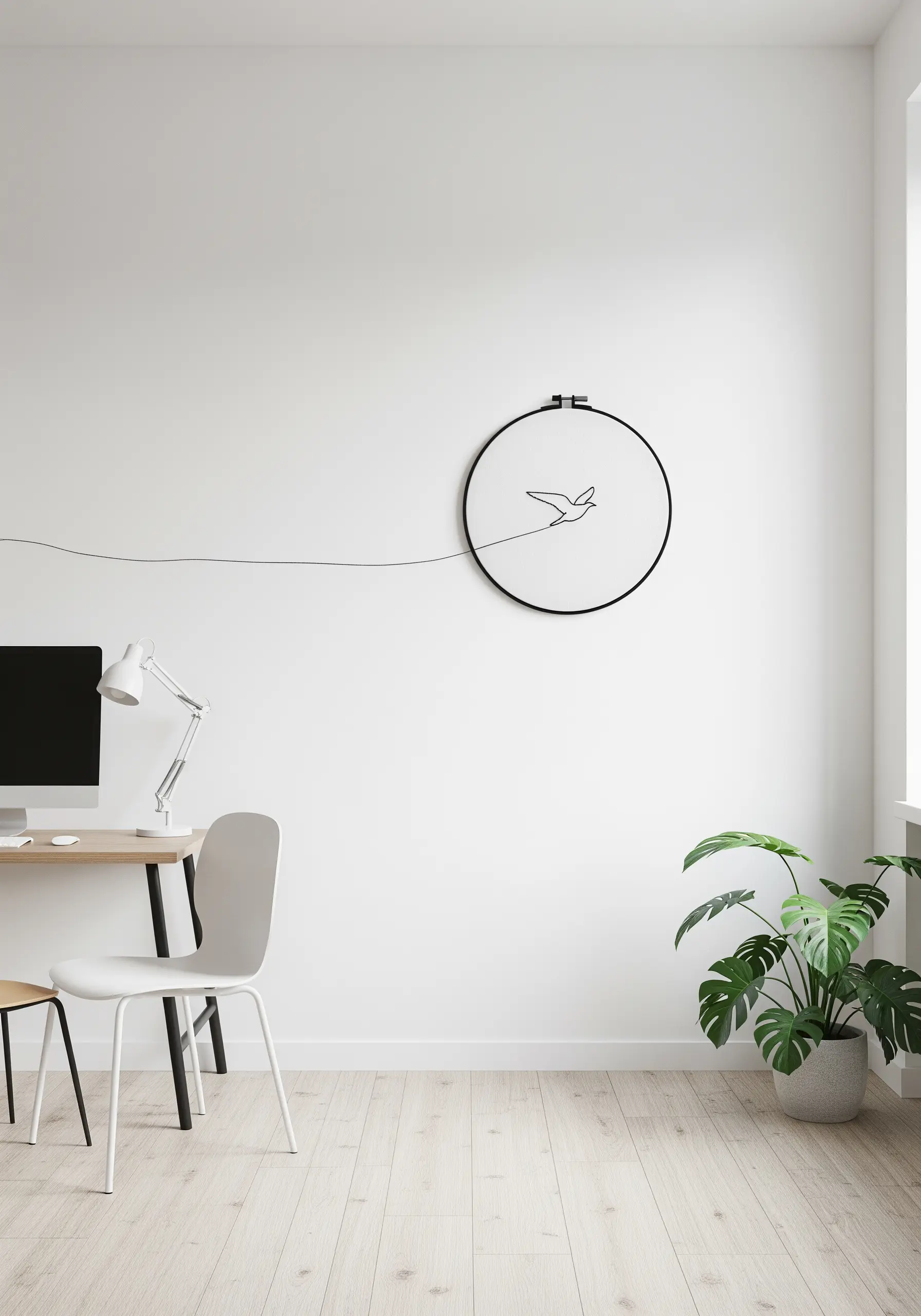 A minimalist bird outline stitched in a black hoop, with the thread extending out to the left.