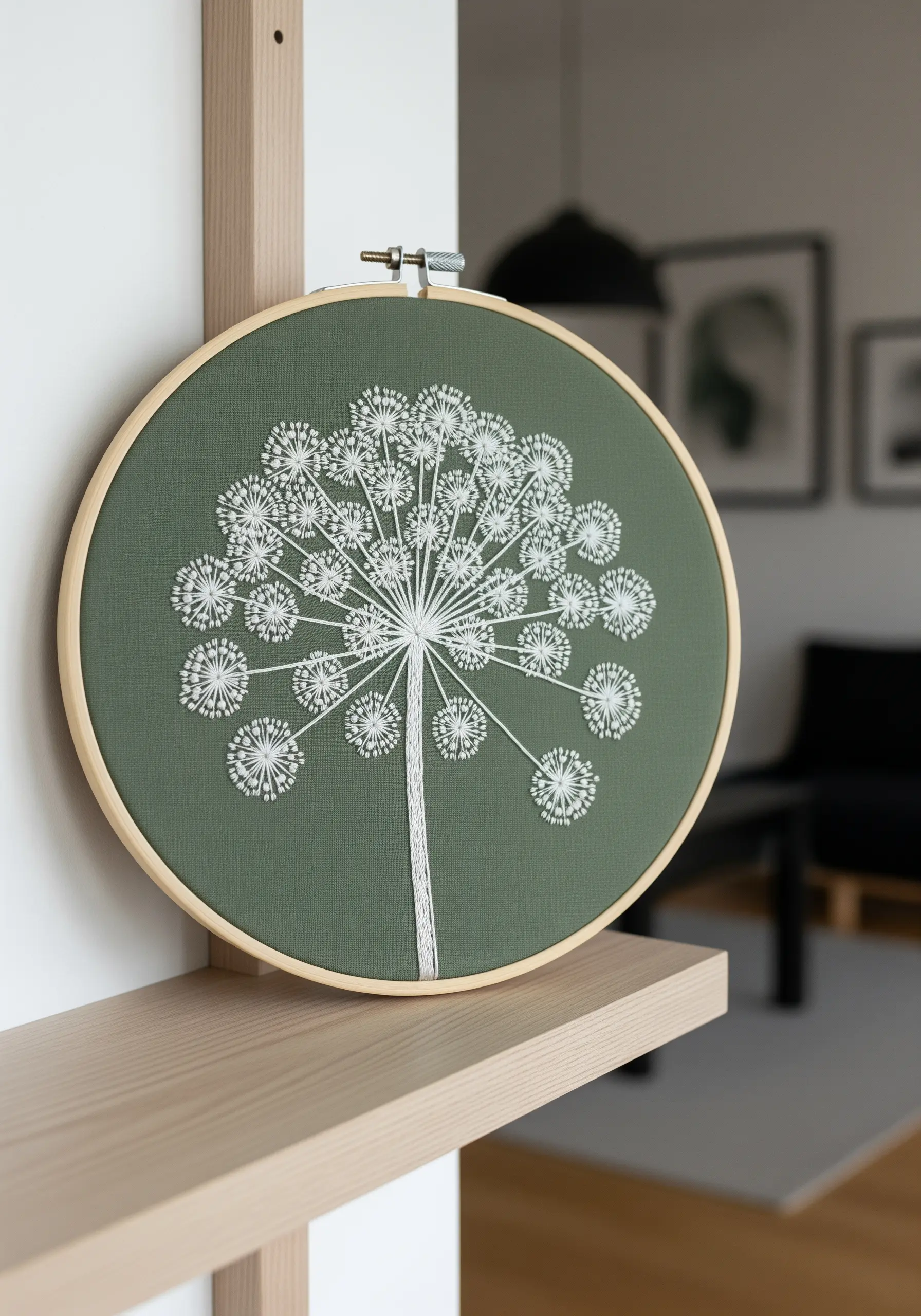 A minimalist white embroidery of an Angelica flower on sage green fabric.