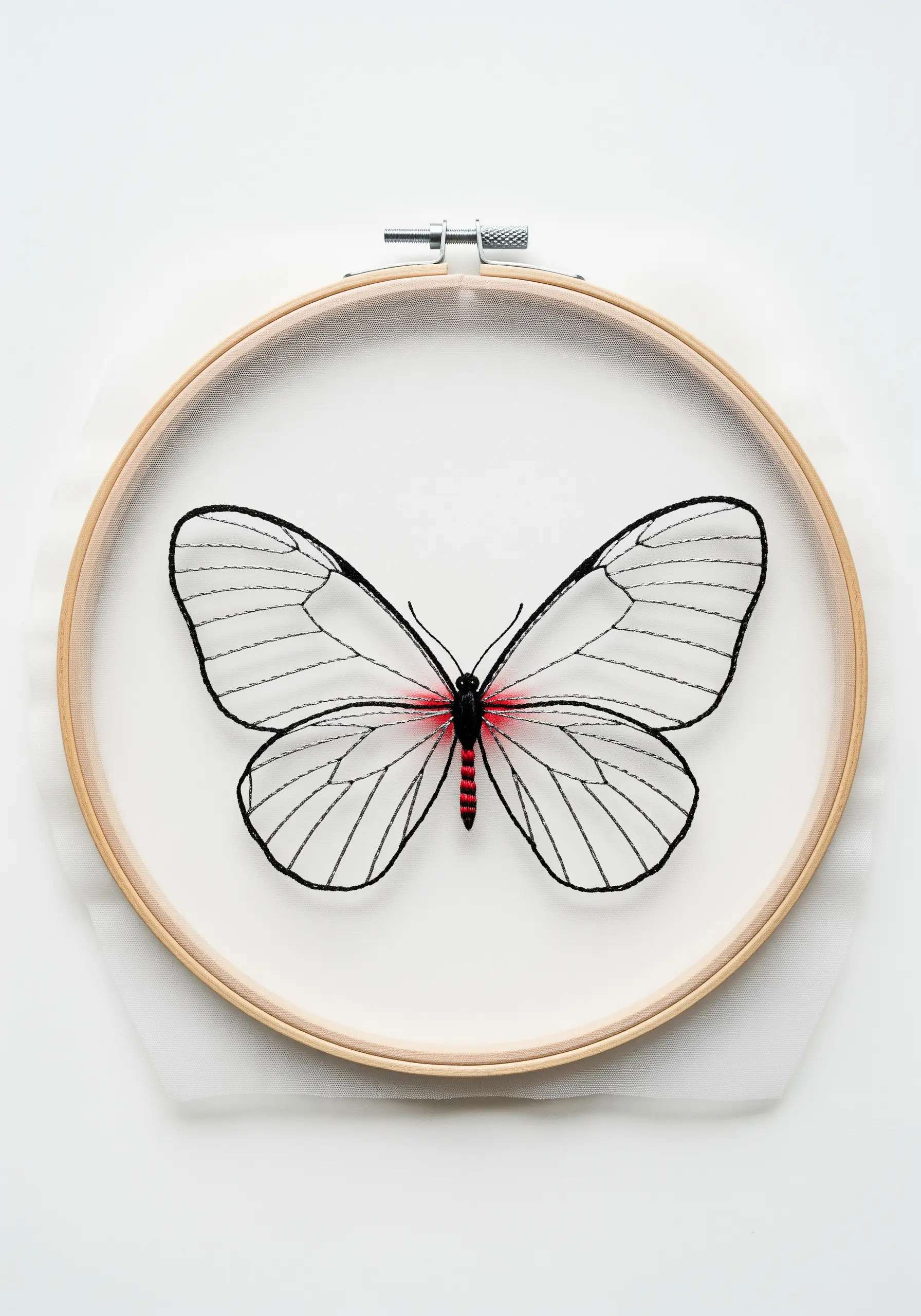 A delicate glasswing butterfly embroidered with black outlines on transparent tulle fabric.