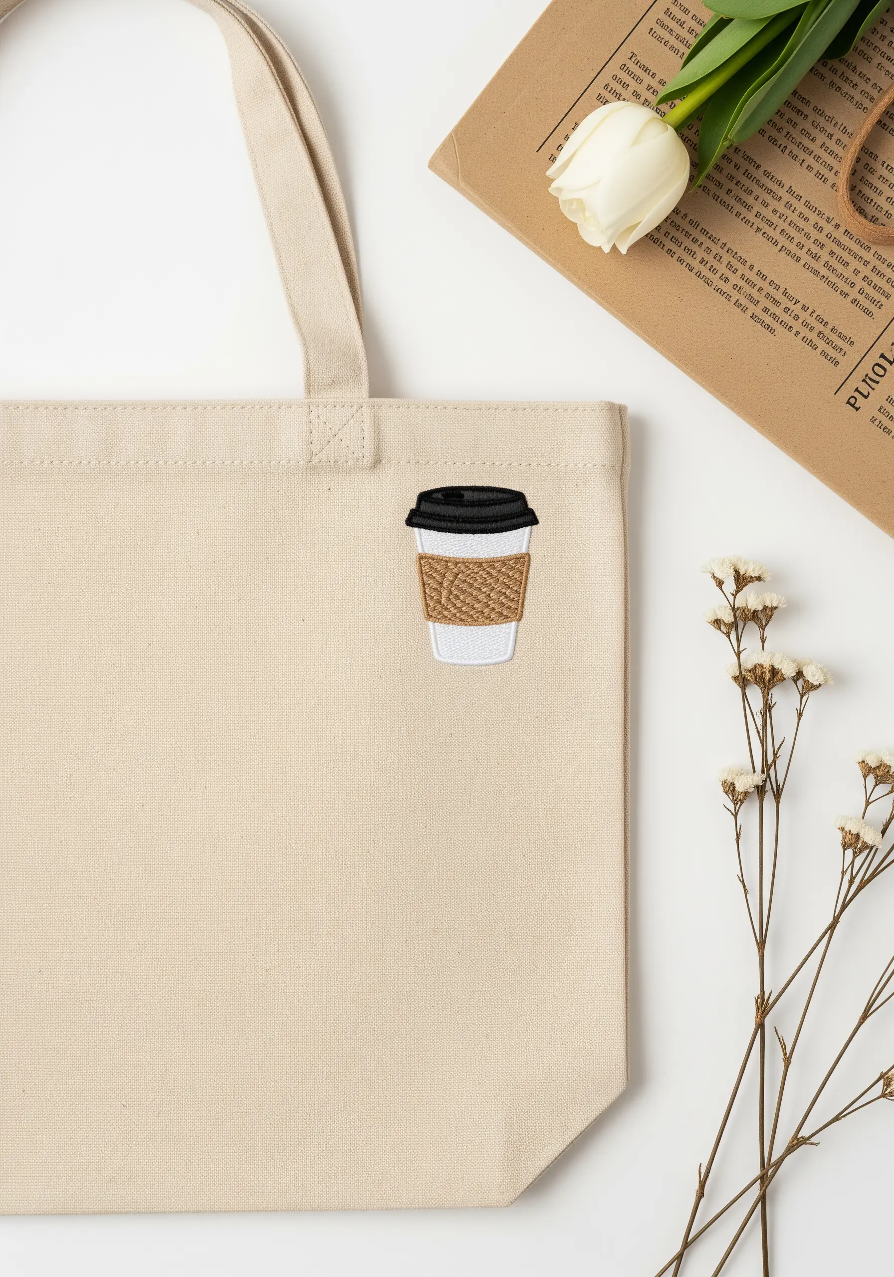 A small, minimalist embroidered patch of a disposable coffee cup with a textured sleeve.