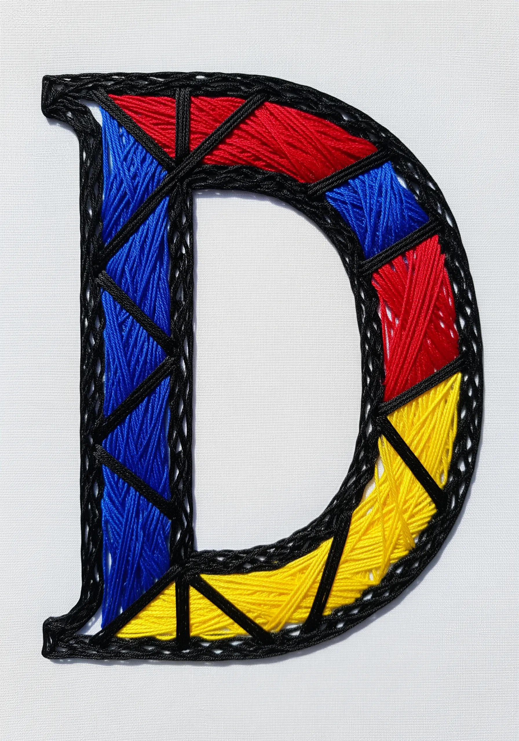 A monogram embroidered to look like stained glass with bold black outlines.