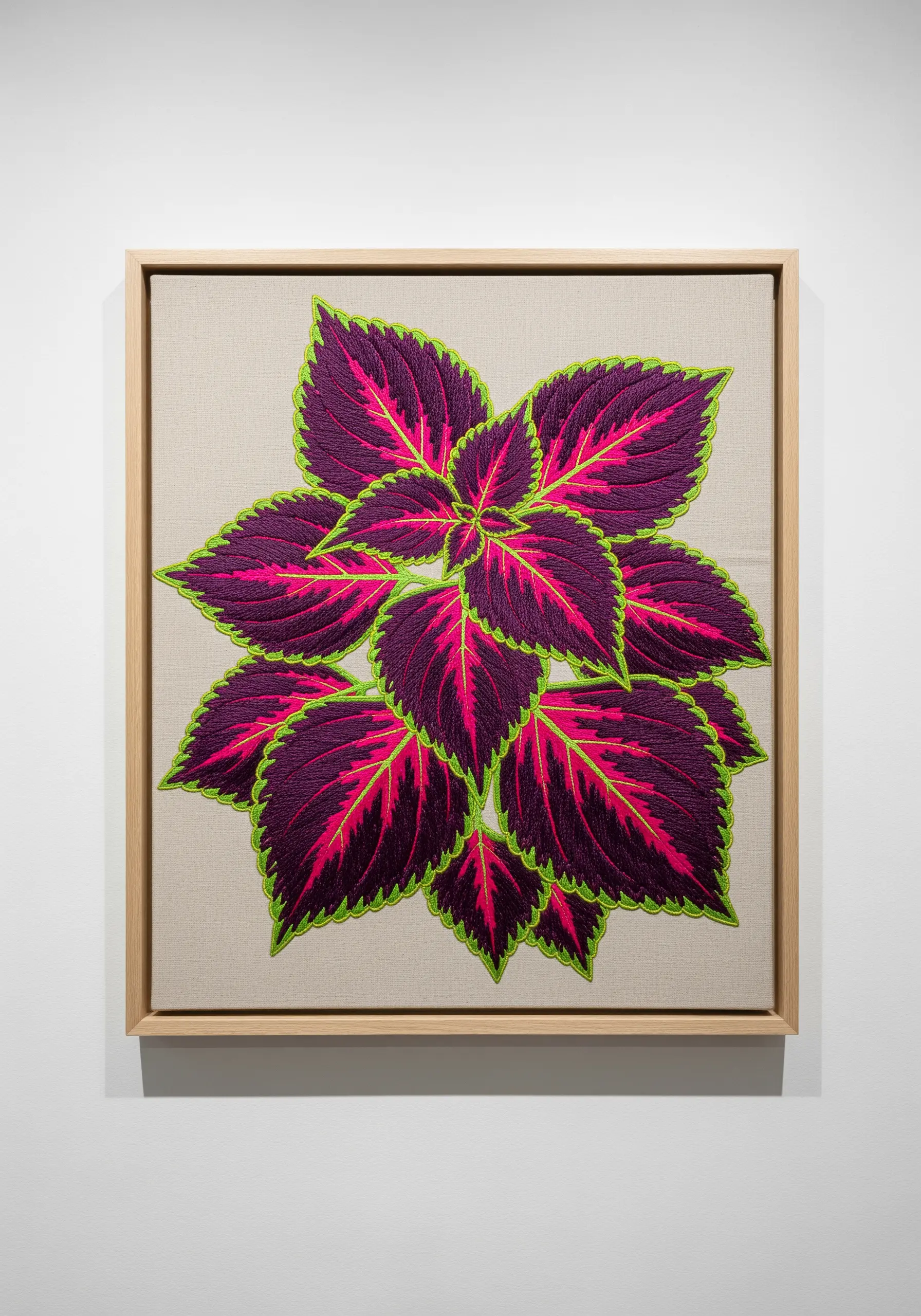 Framed embroidery of a Coleus plant with deep purple, pink, and neon green leaves.