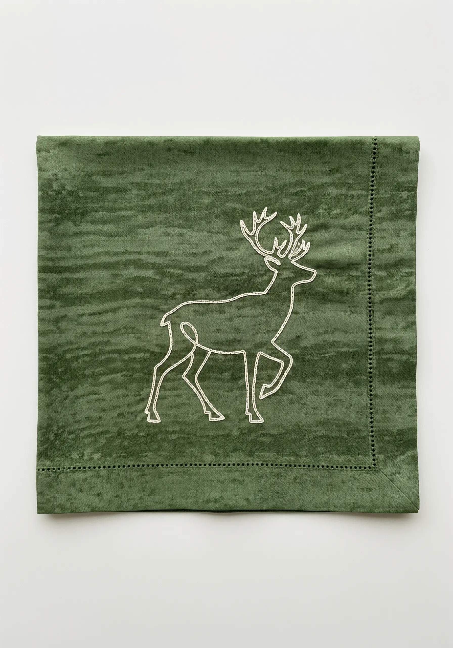 A reindeer embroidered in a thick white outline on a dark green napkin.